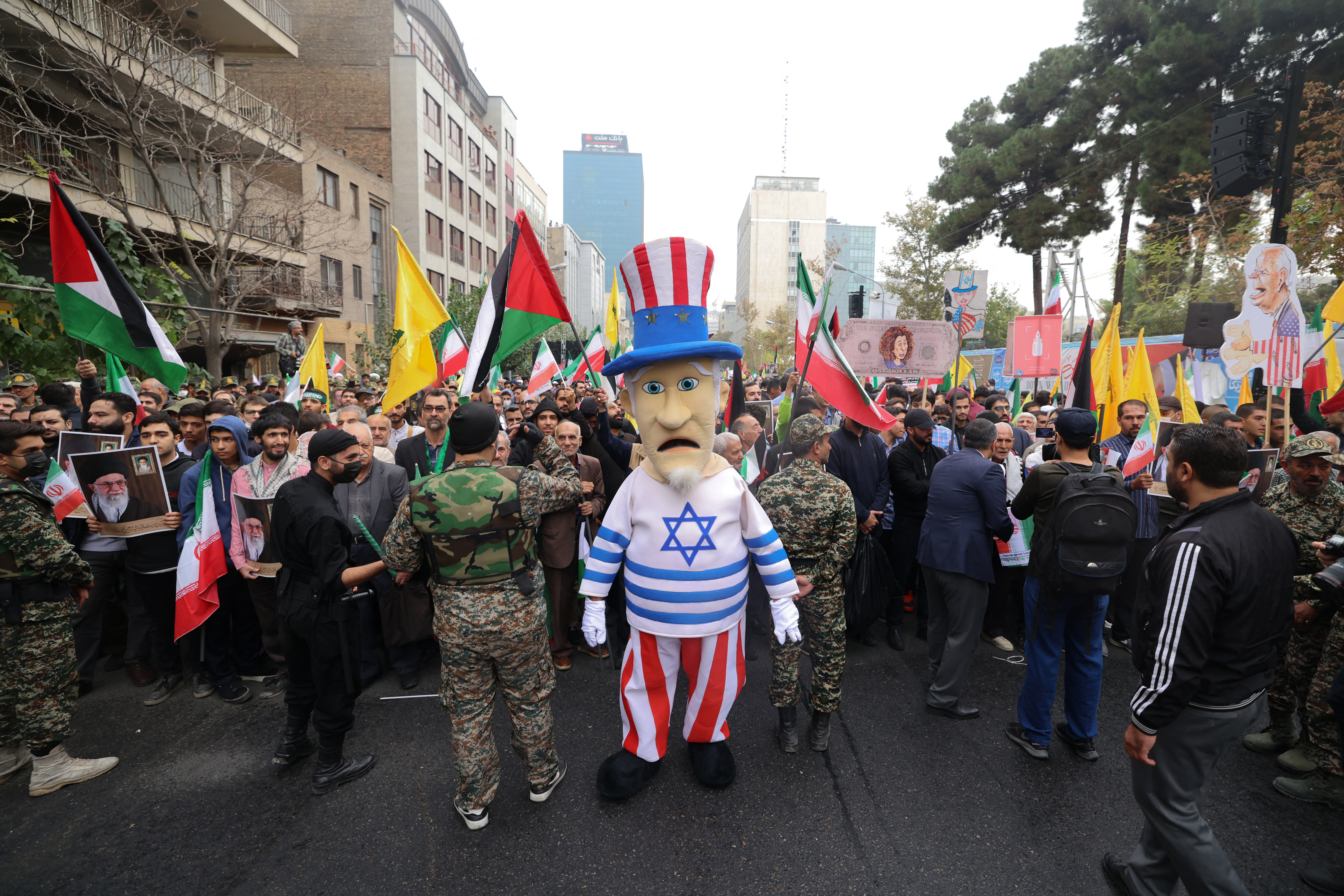A man is dressed in an 'uncle Sam' outfit wearing a shirt in the colours of the Israeli flag, takes part in a rally outside the former US embassy in Tehran, to support the Palestinians of the Gaza Strip.