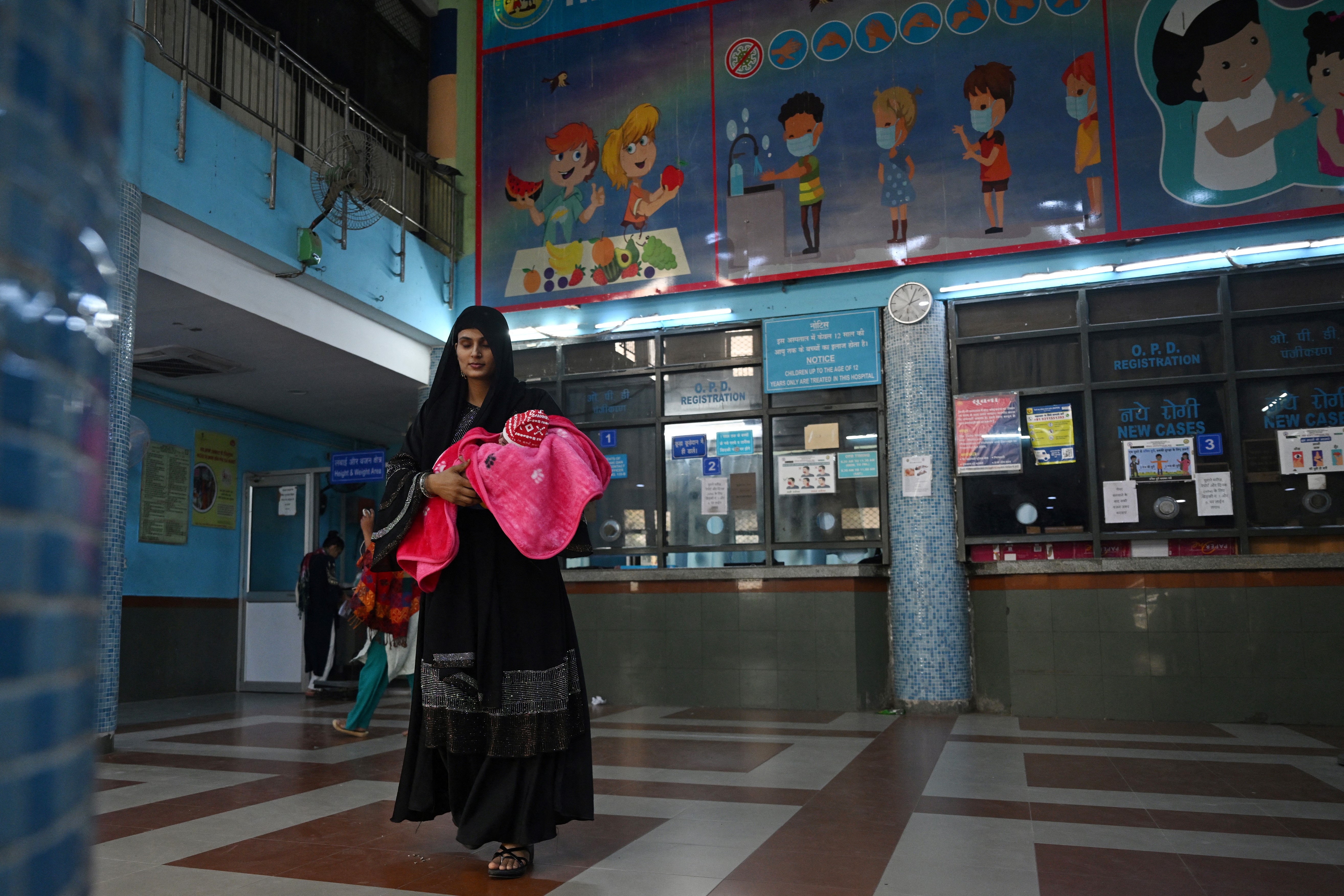 In this picture taken on November 7, 2023, a mother with her child leaves after receiving treatment at the government-run Chacha Nehru Bal Chikitsalaya children hospital in New Delhi.