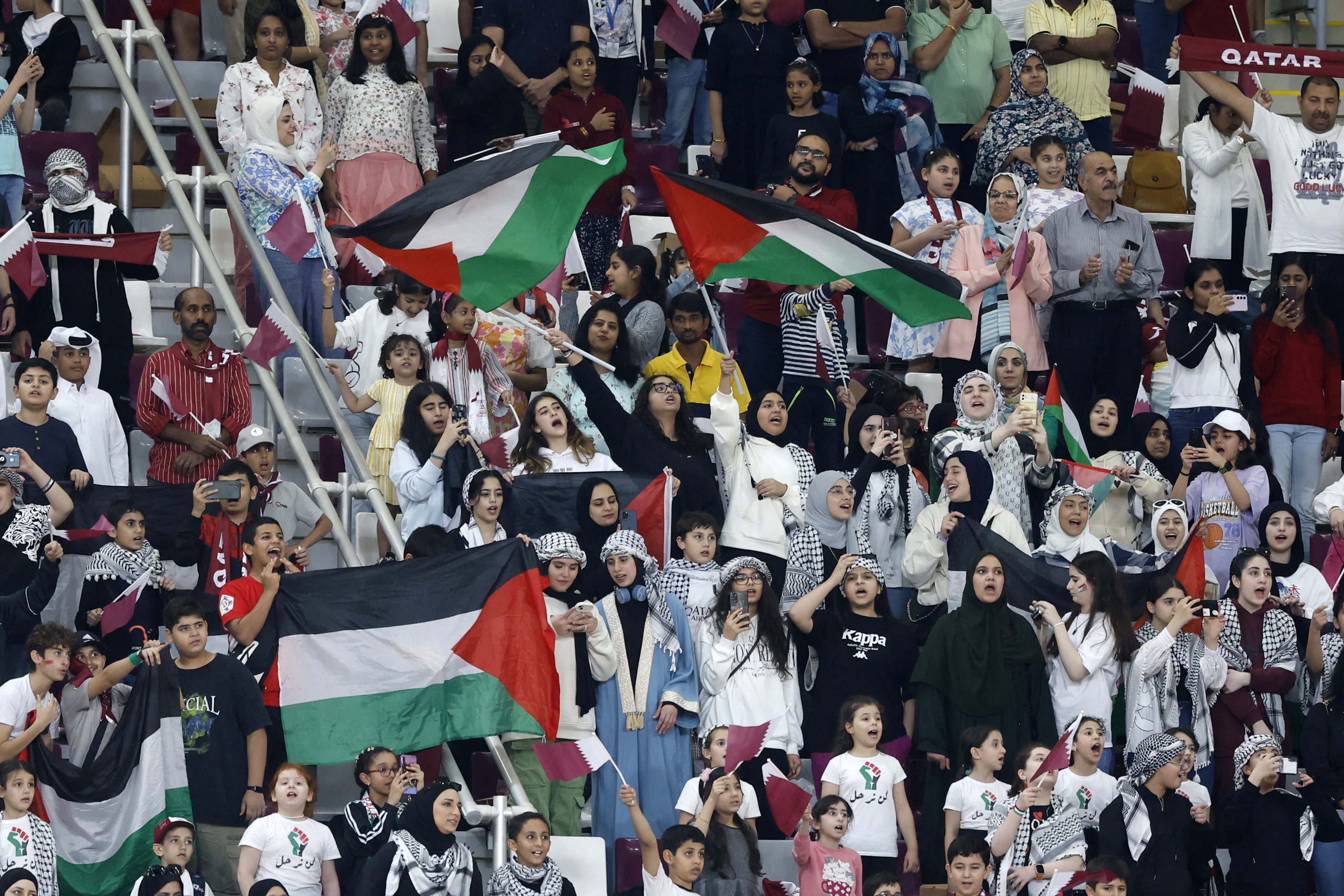 Fans wave the Palestinian flag during the 2026 FIFA World Cup AFC qualifiers football match between Qatar and Afghanistan at the Khalifa International Stadium.