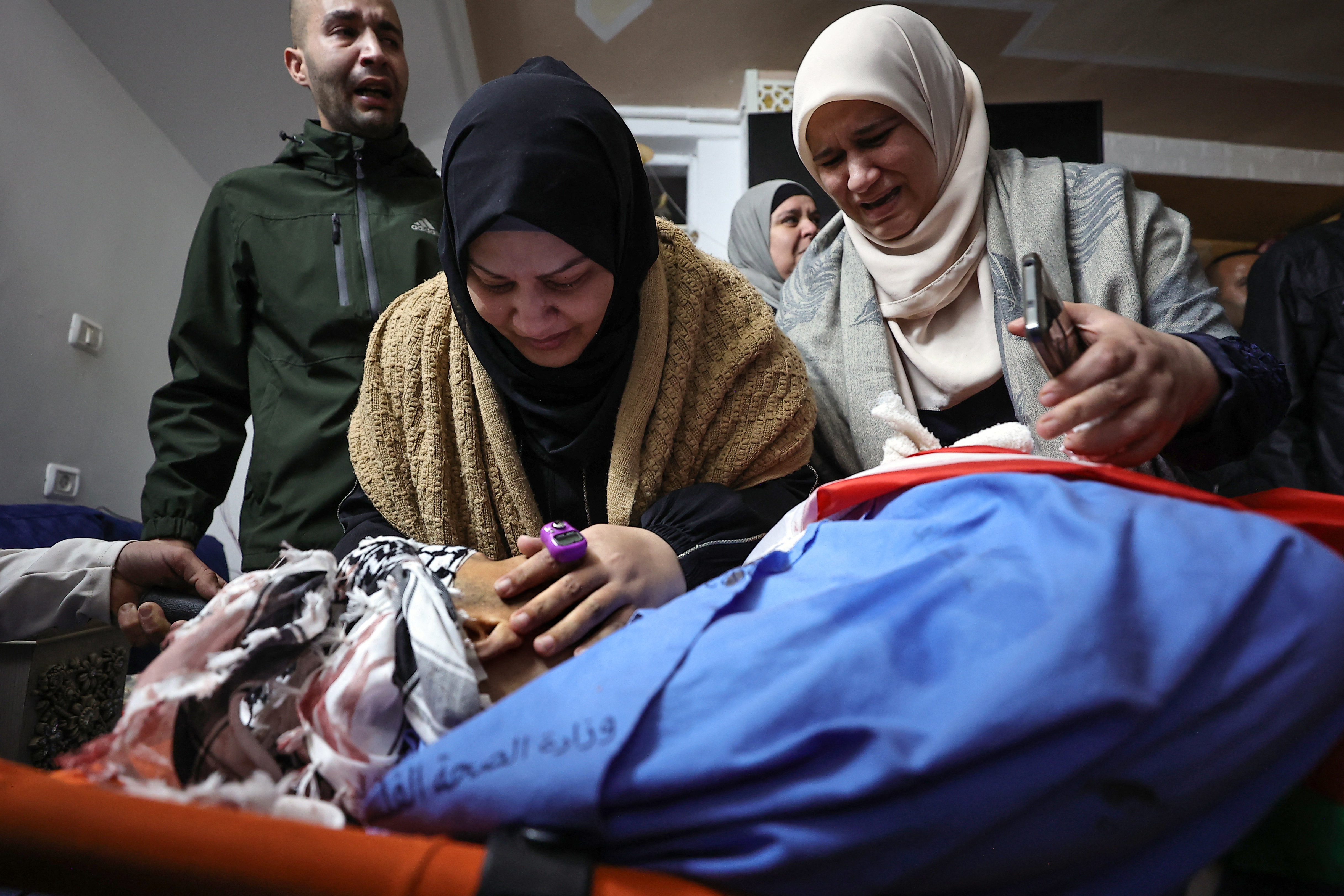 Palestinians mourn over the body of a relative during the funeral for six Palestinians killed in clashes with Israeli forces in the northern occupied West Bank city of Tulkarem.