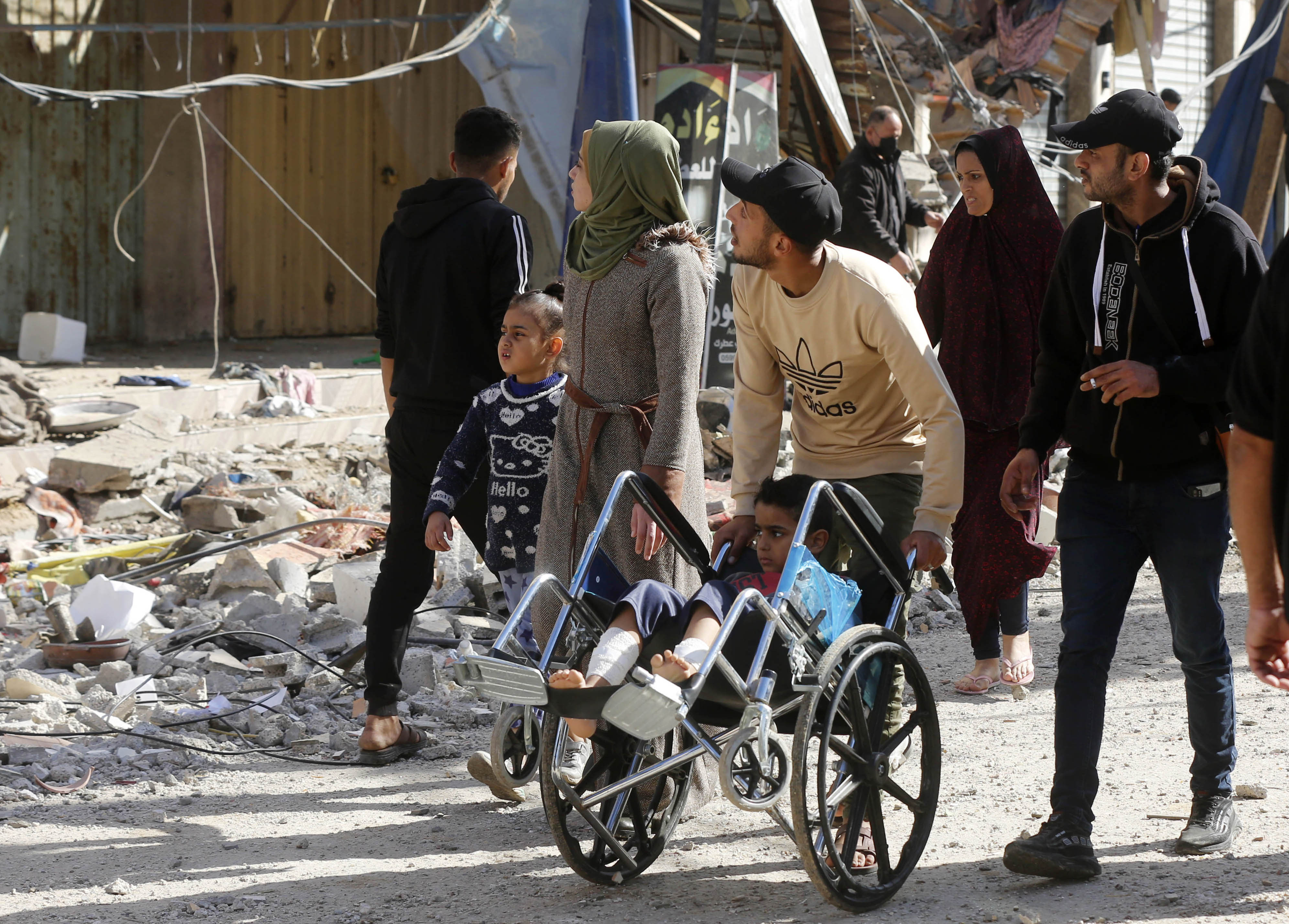 Palestinians leave the area as many buildings are heavily damaged due to Israeli attacks on Nuseirat Refugee Camp in Deir al-Balah, Gaza.