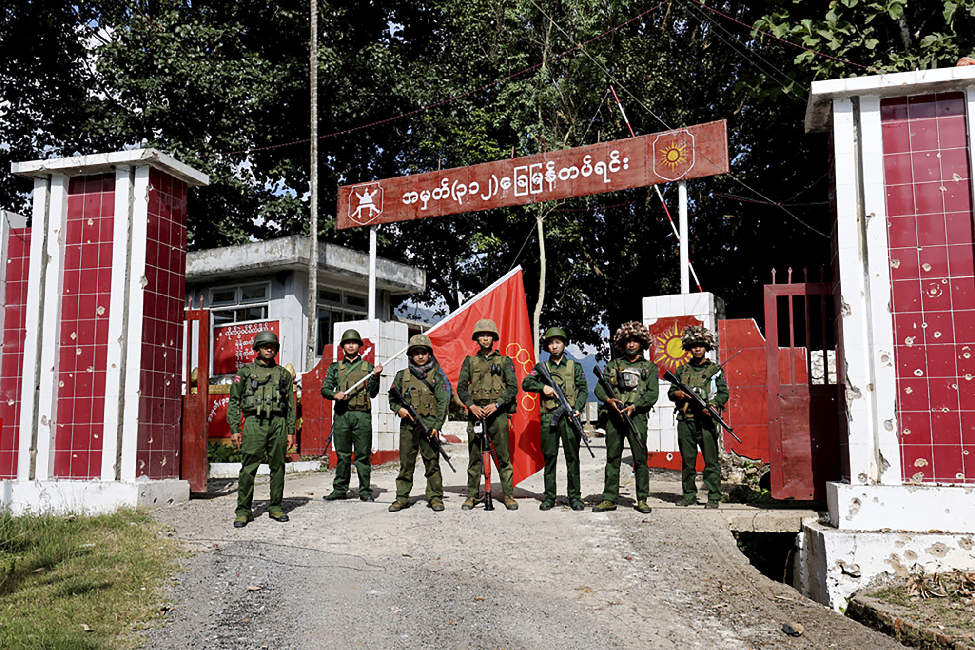 Members of the Myanmar National Democratic Alliance Army pose for a photo in front of a seized military outpost in Shan state. They are holding their red flag aloft