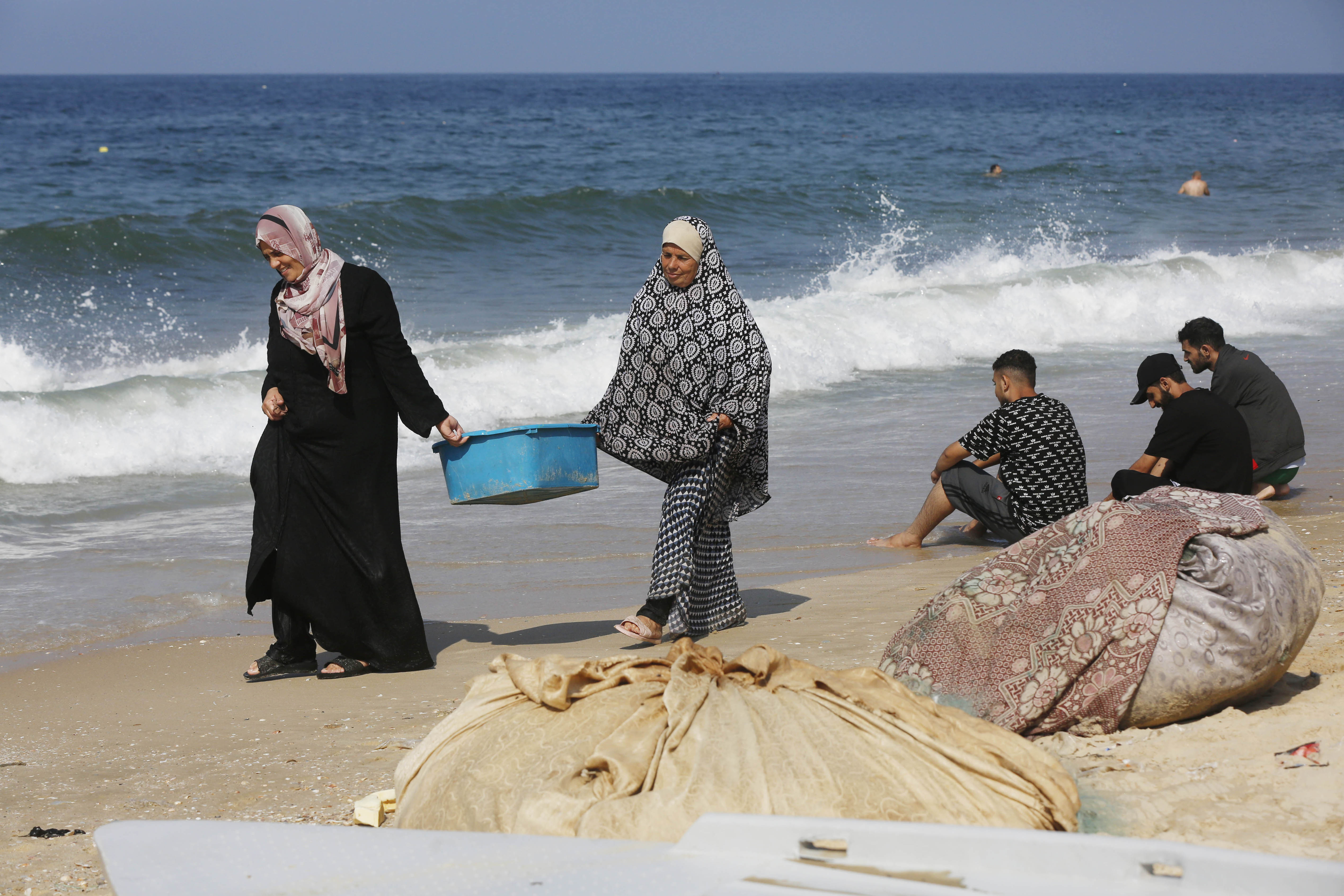 Palestinians using the sea to wash their clothes and bathe