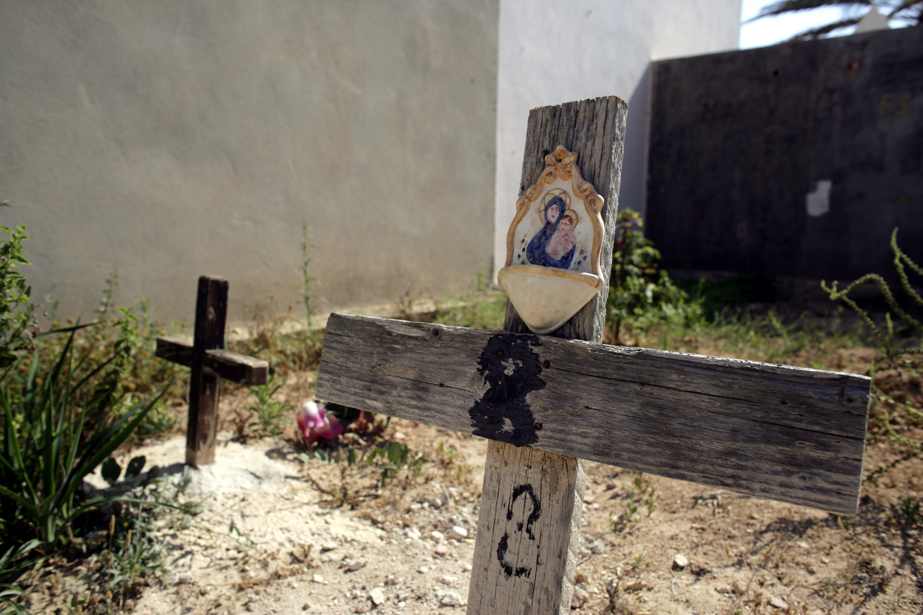 Makeshift wooden crosses mark the graves of unnamed refugees who died on sea voyages to Lampedusa, pictured in 2004 when Vincenzo was still the graveyard keeper