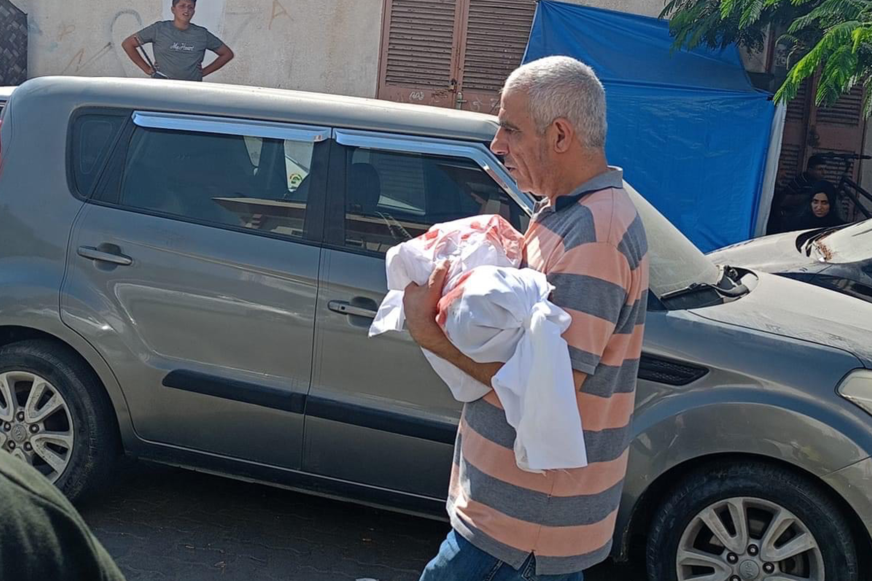 Jameel, Julia’s grandfather, carrying her body before her funeral [Courtesy of Ghada Ageel]