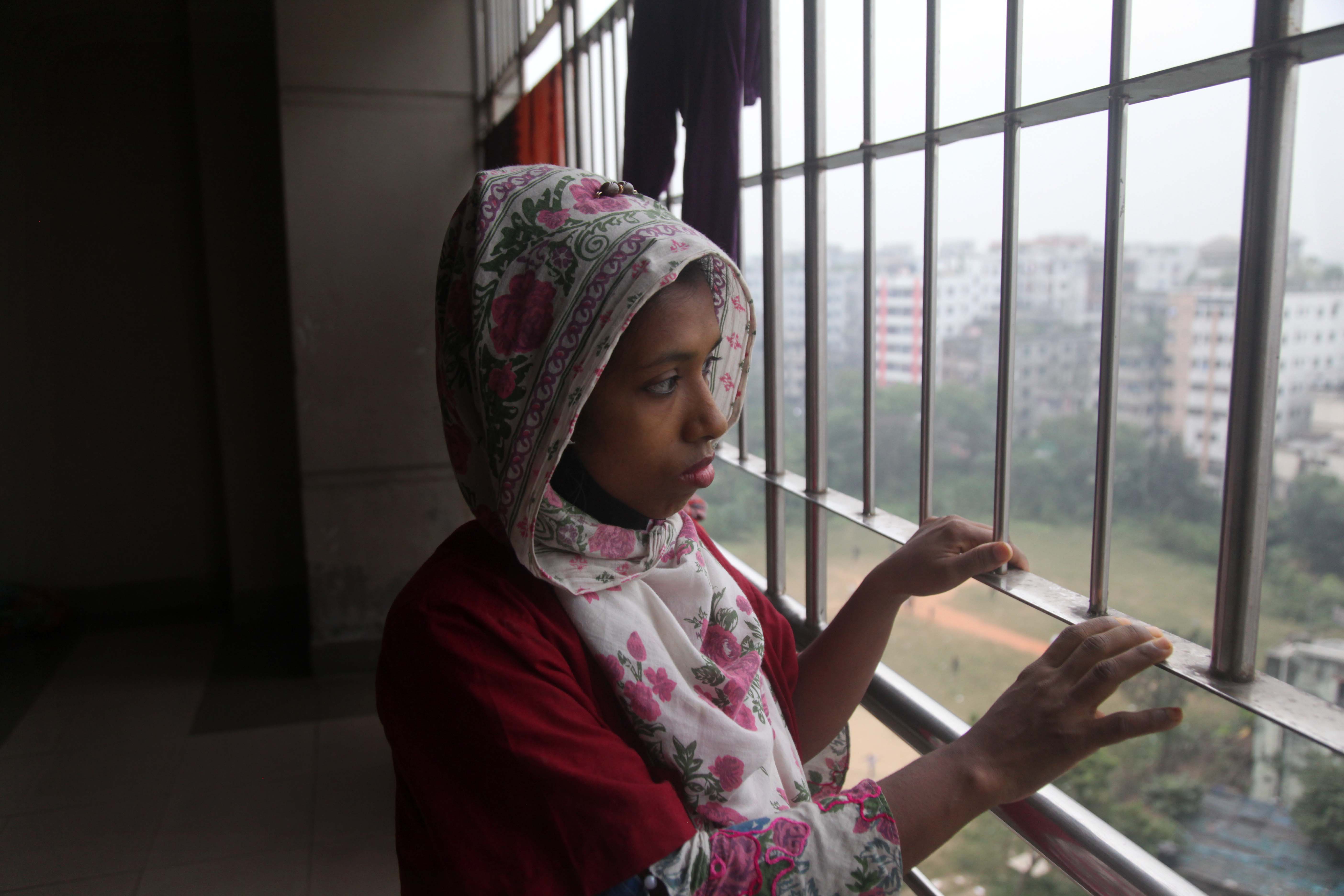 Mosammat Mayna looks out of the window of the hospital where she works