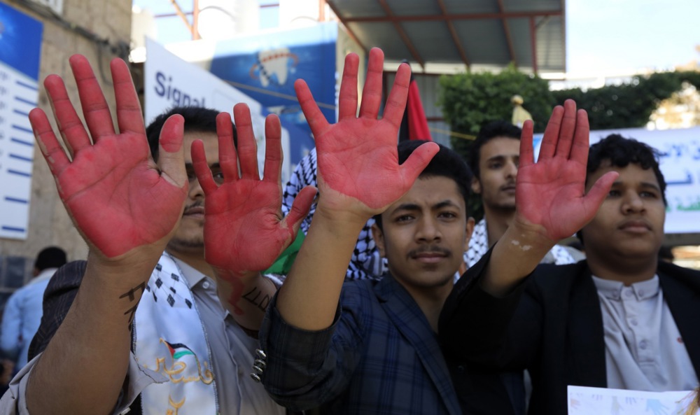 Protesters raise their hands painted with mock blood during a vigil in solidarity with the Palestinian people, in Sana'a, Yemen.