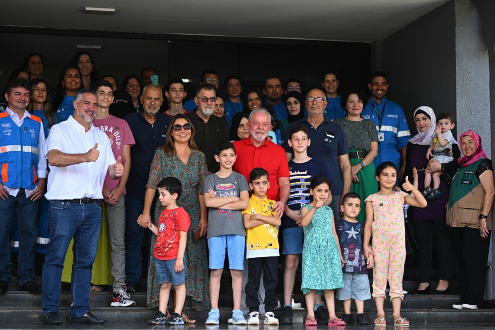epa11044147 Brazilian President Luiz Inacio Lula da Silva (C) poses with a group of Brazilian citizens and their Palestinian relatives who were repatriated from the Gaza Strip on 23 December, in Brasilia, Brazil, 25 December 2023. This was the 12th repatriation flight coordinated by Brazil's Federal Government since the militant group Hamas launched an unprecedented attack on Israel from the Gaza Strip on 07 October. EPA-EFE/ANDRE BORGES