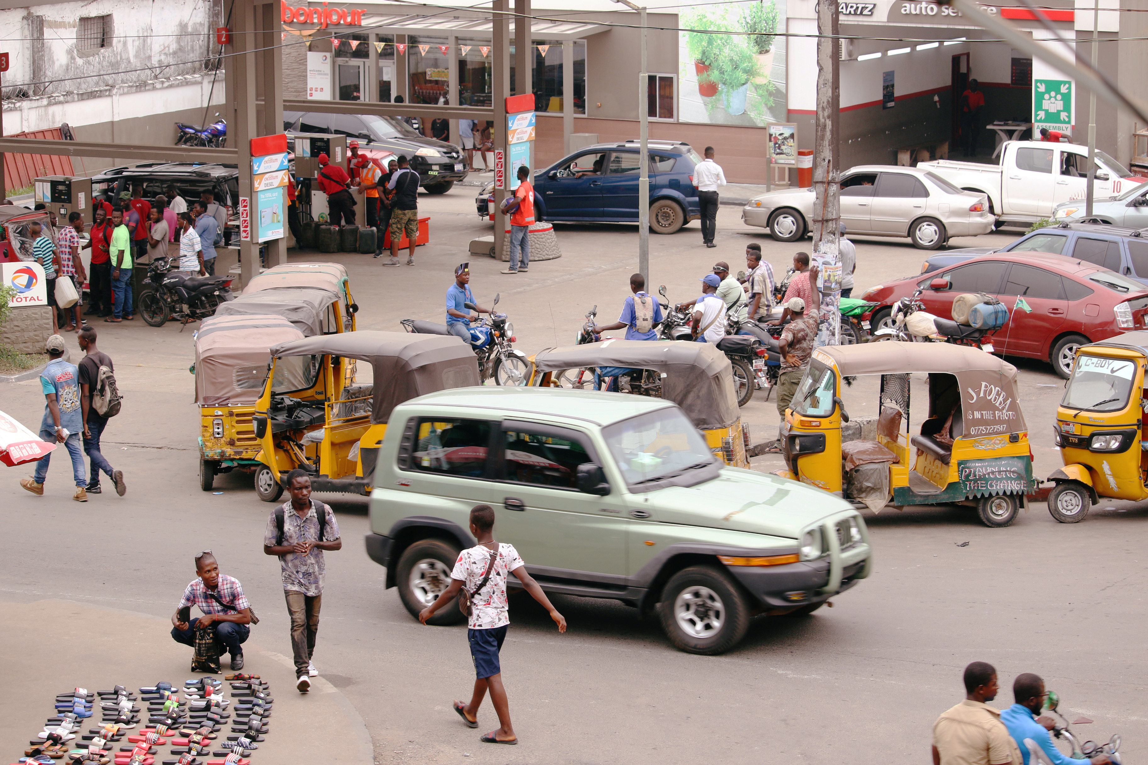 Motorcycle taxis, called kekeh in Liberia, stand in line waiting to refuel