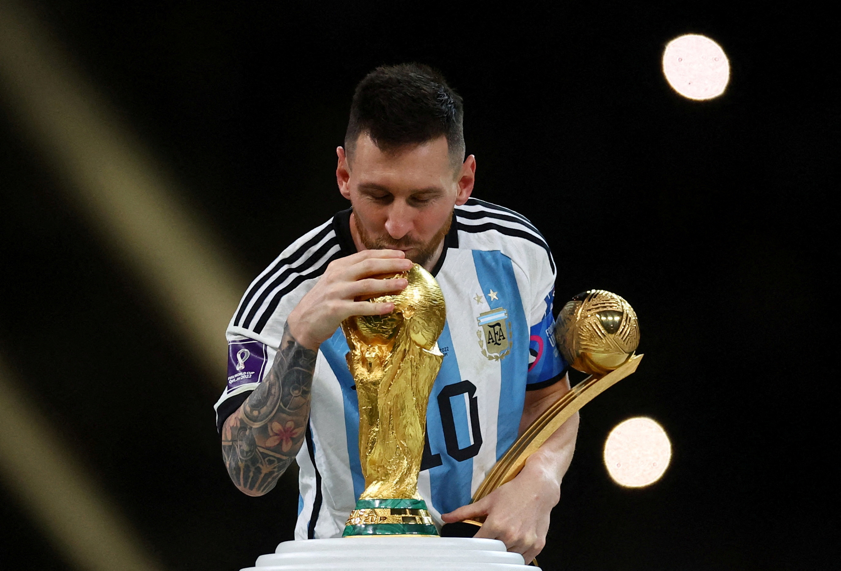 Lionel Messi kissing the World Cup.