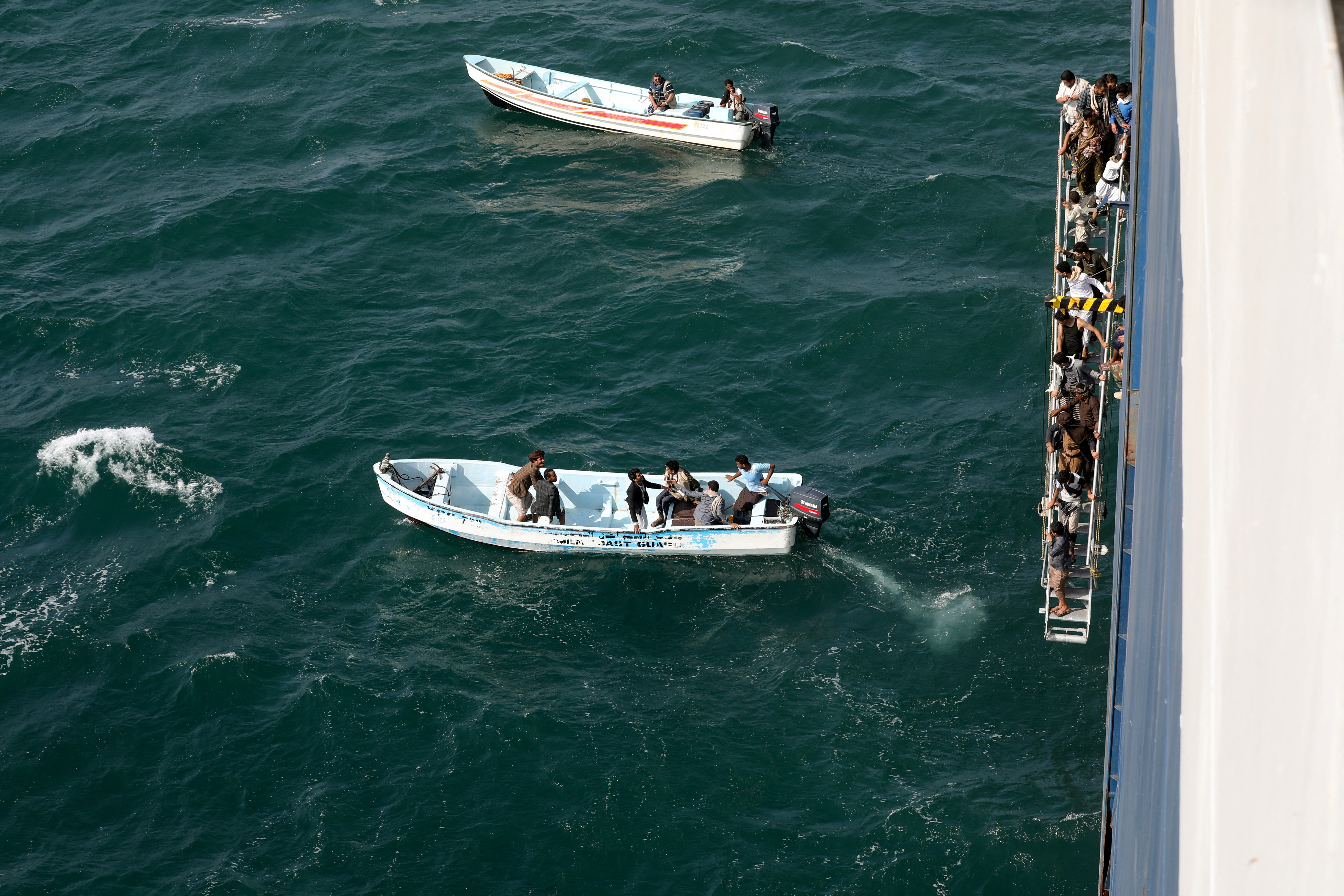 People walk down a ladder after they toured the Galaxy Leader commercial ship, seized by Yemen's Houthis last month, off the coast of al-Salif