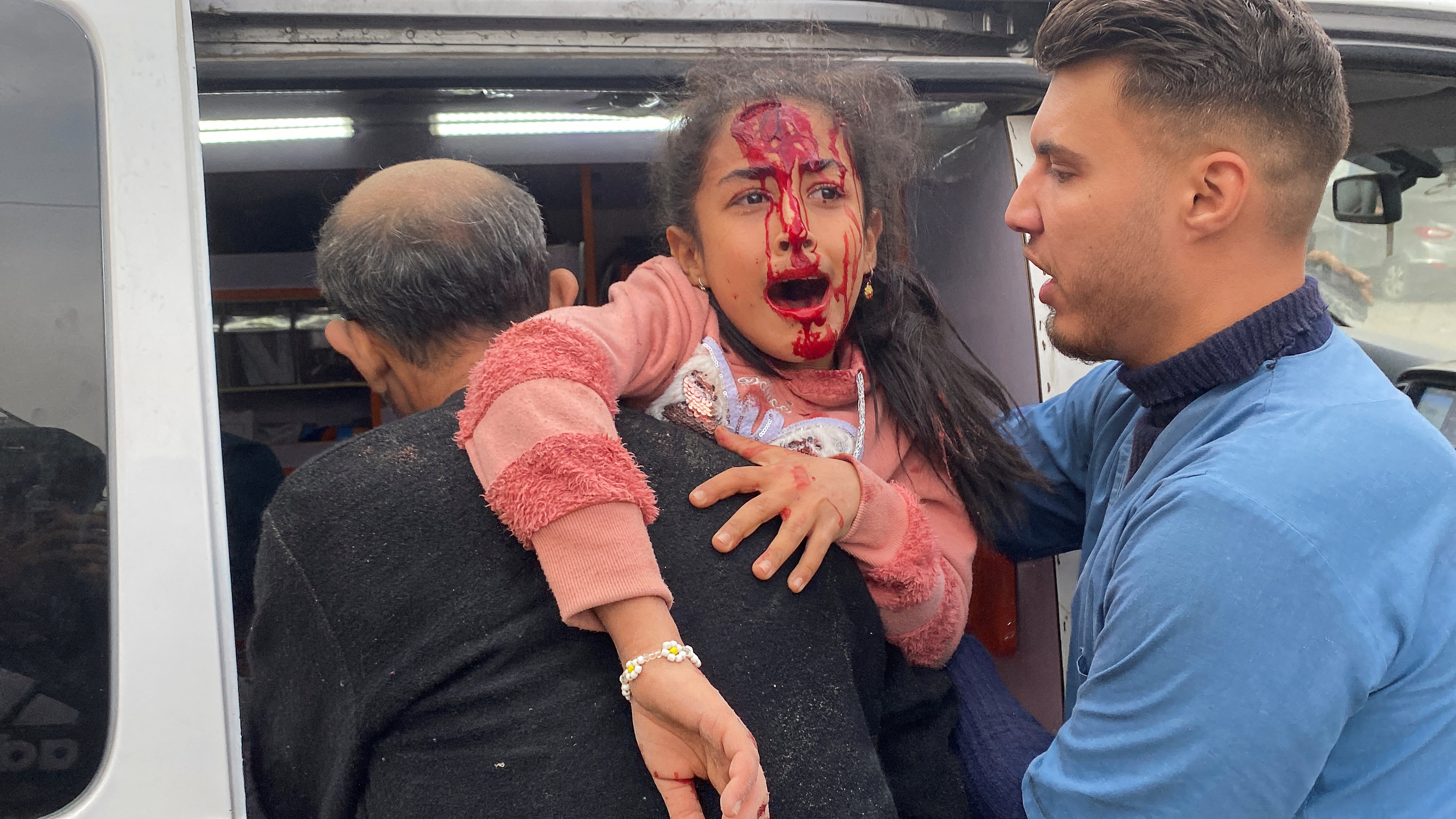 An injured Palestinian girl is carried to an ambulance, at the site of an Israeli strike, amid the ongoing conflict between Israel and the Palestinian Islamist group Hamas, in Rafah in the southern Gaza Strip.