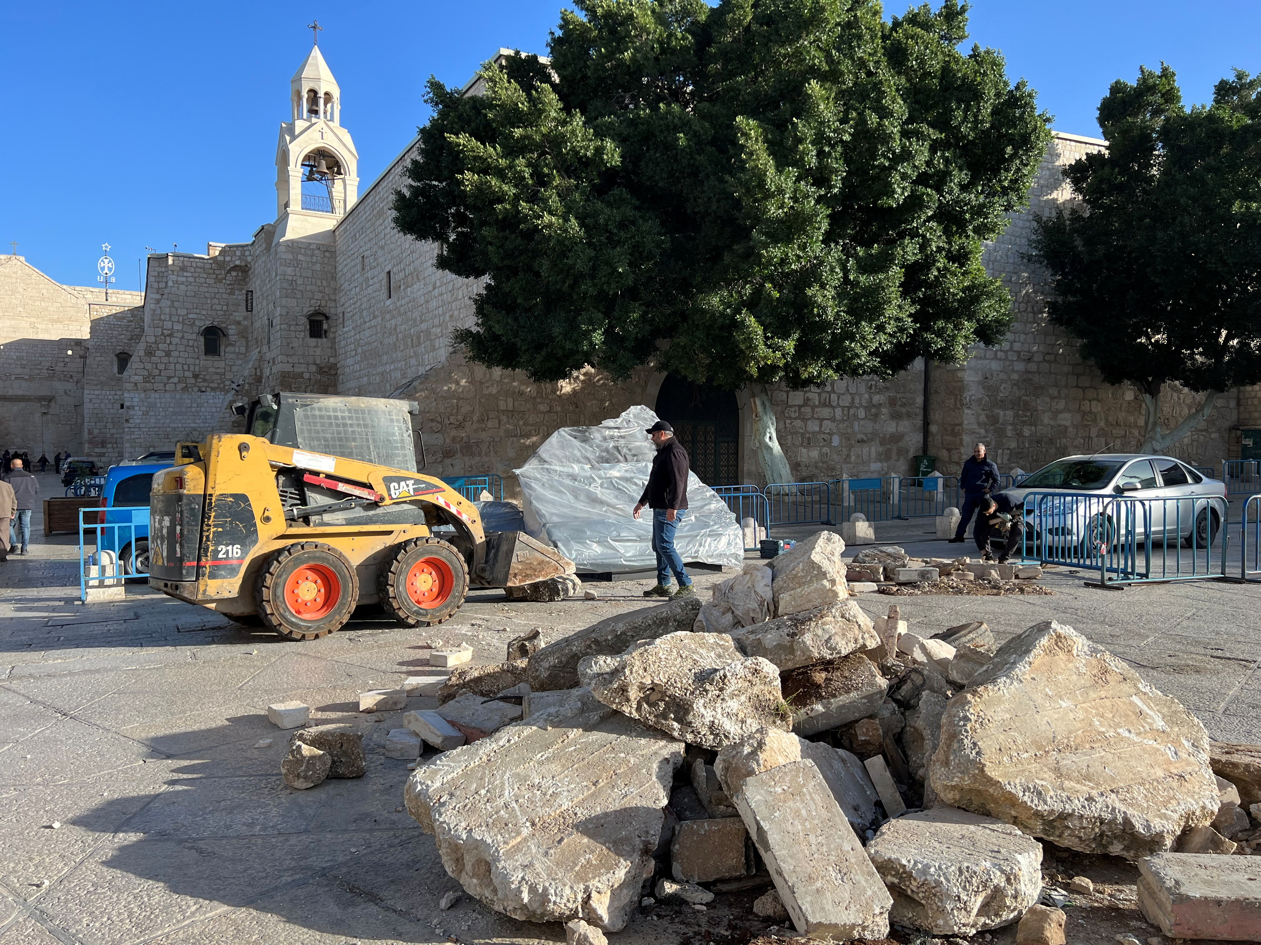 Workers prepare Christmas installation of grotto at manger square outside Church of Nativity in support with Gaza, in Bethlehem in the Israeli-occupied West Bank