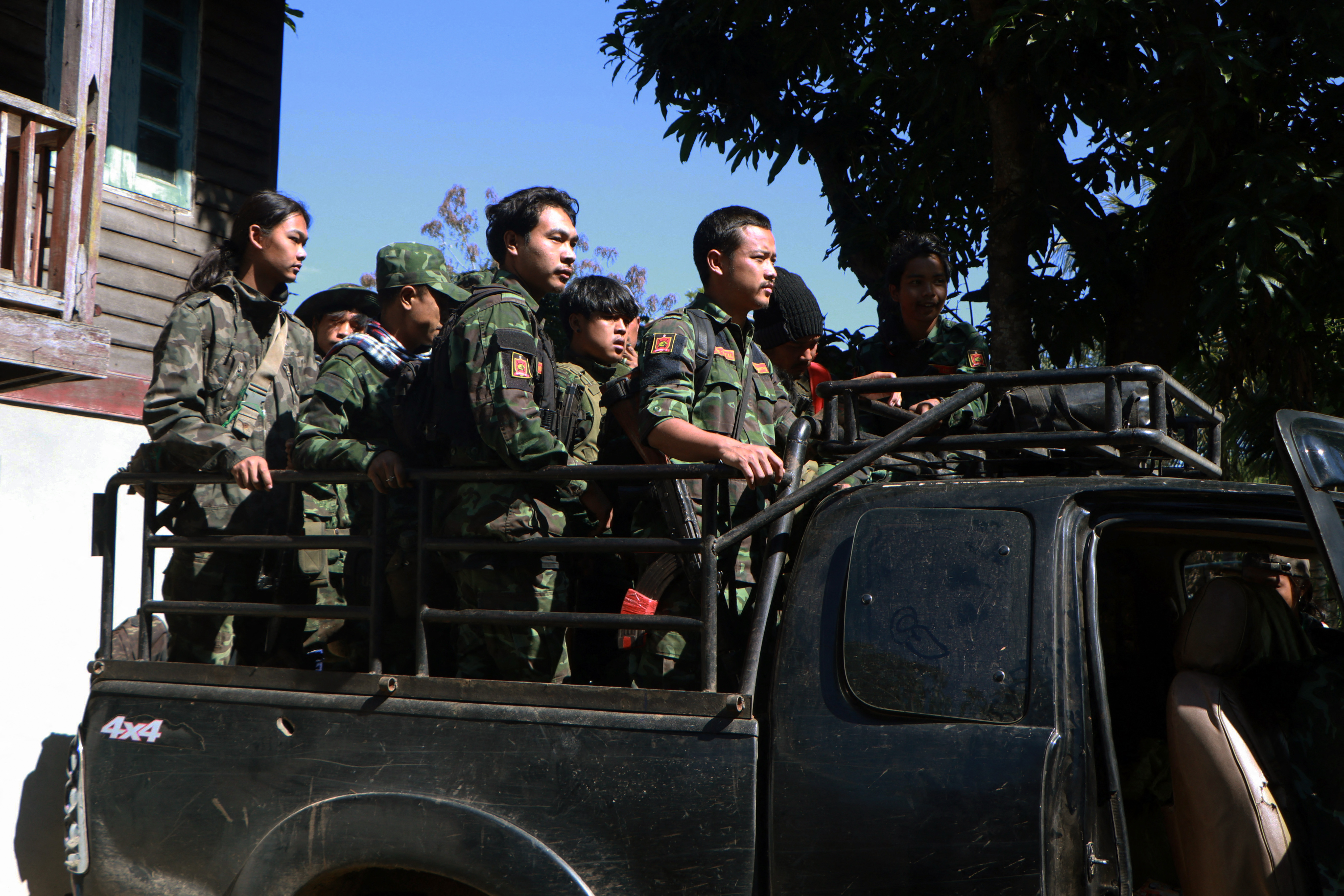 A group from the Loikkaw People's Defence Force (PDF) stand on the back of a truck on their way to the front line in Myanmar's eastern Kayah state