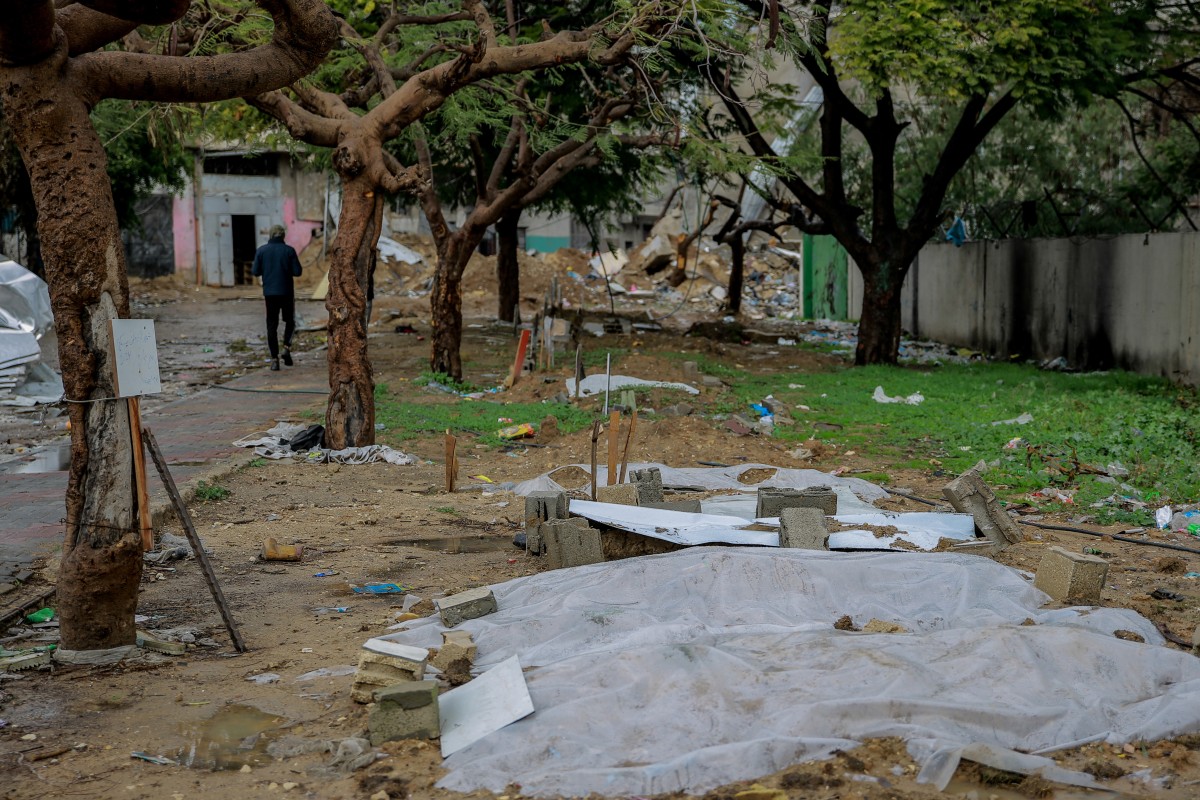 Shallow tombs of people killed in Israeli bombing are lined up at makeshift cemetery next to Al-Mahatta Park in the eastern al-Tuffah neighbourhood of Gaza City