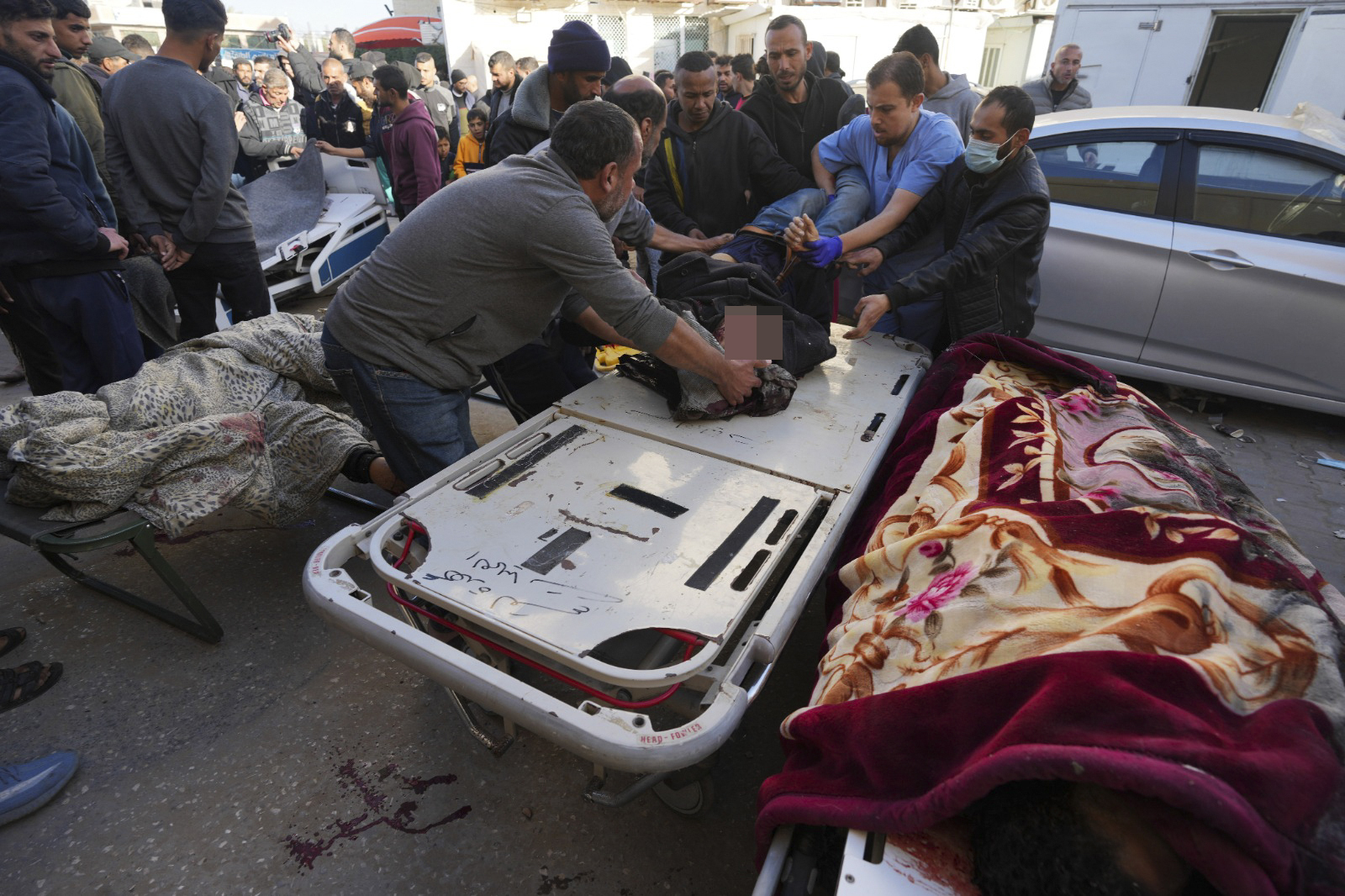 Palestinians bring people killed after an Israeli strike hit a building next to the Al-Aqsa Hospital in Deir al Balah