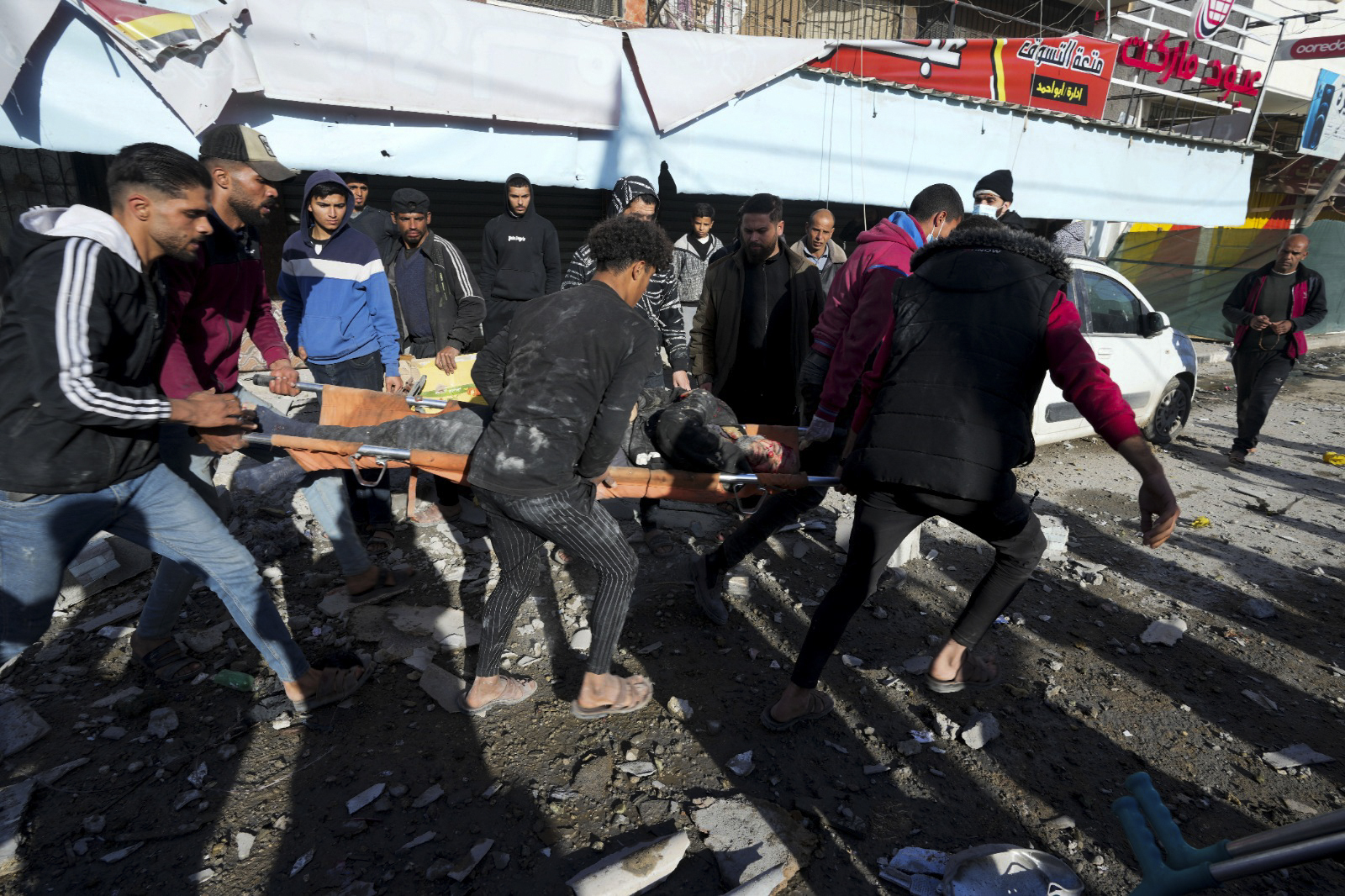 Palestinians evacuate wounded after an Israeli strike hit a building next to the Al-Aqsa Hospital in Deir el-Balah, Gaza Strip, on Wednesday, Jan 10, 2023. [AP Photo/Adel Hana]