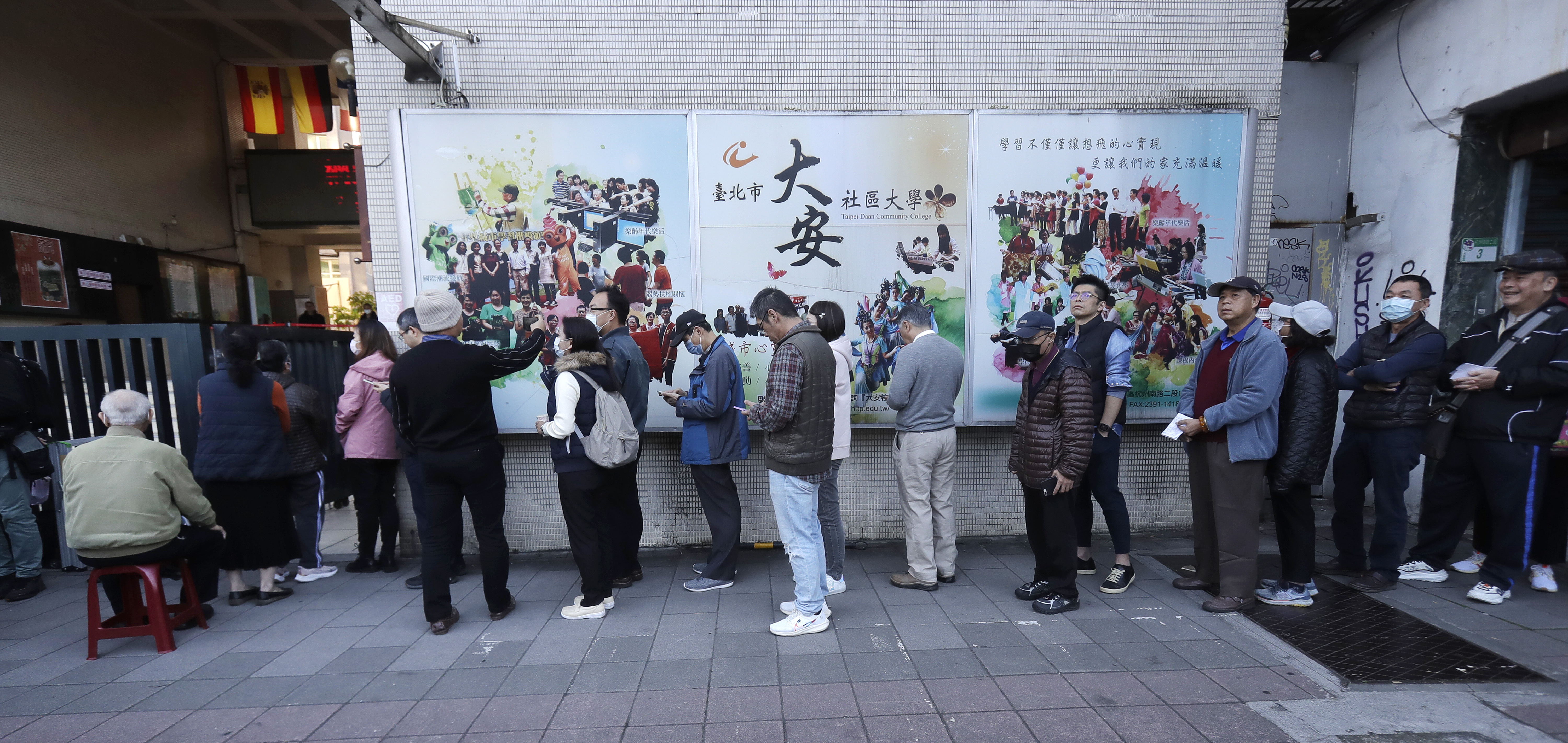 Taiwanese people line up to vote outside of a polling station in Taipei, Taiwan, Saturday, Jan. 13,