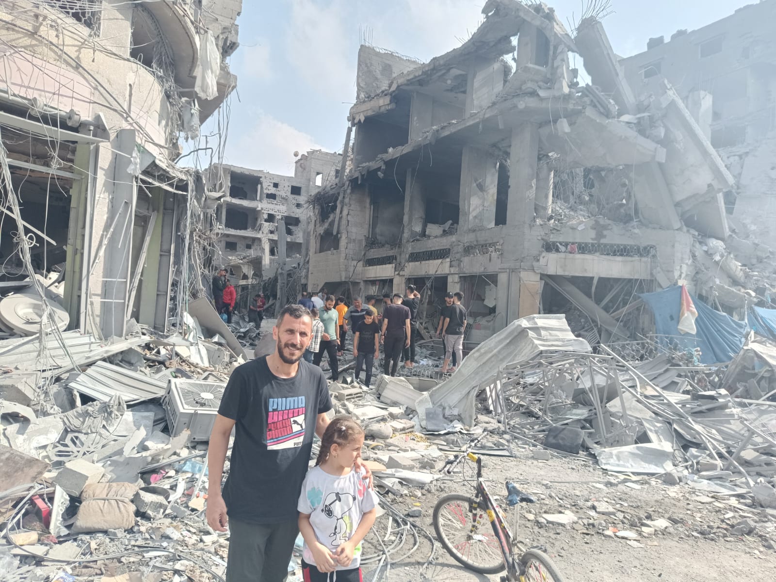 Alhamadni’s brother, Suhail Alhamadni, and Suhail’s daughter Miral stand amid bombing wreckage in Gaza in October [Courtesy Abdallah Alhamadni]