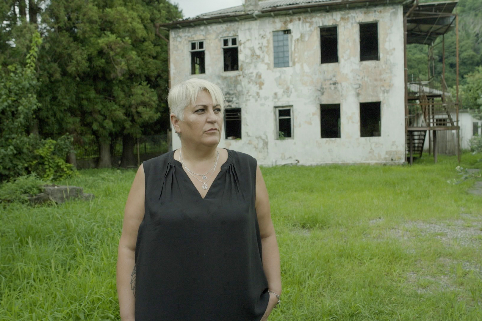 Natalia is standing outside the family house built by her grandfather Hasan which was destroyed in a fire