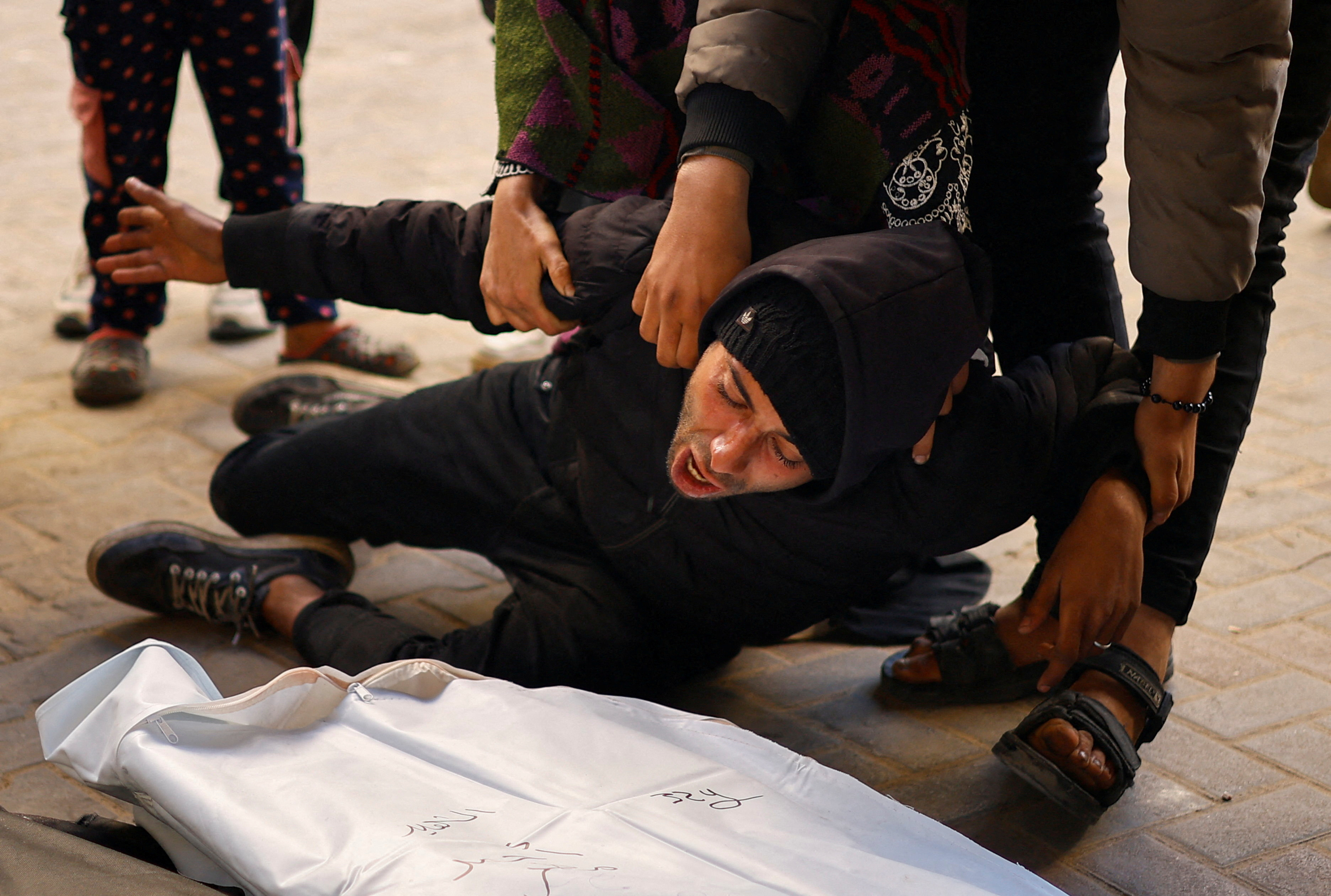 Mourners react next to the bodies of Palestinians killed in Israeli strikes