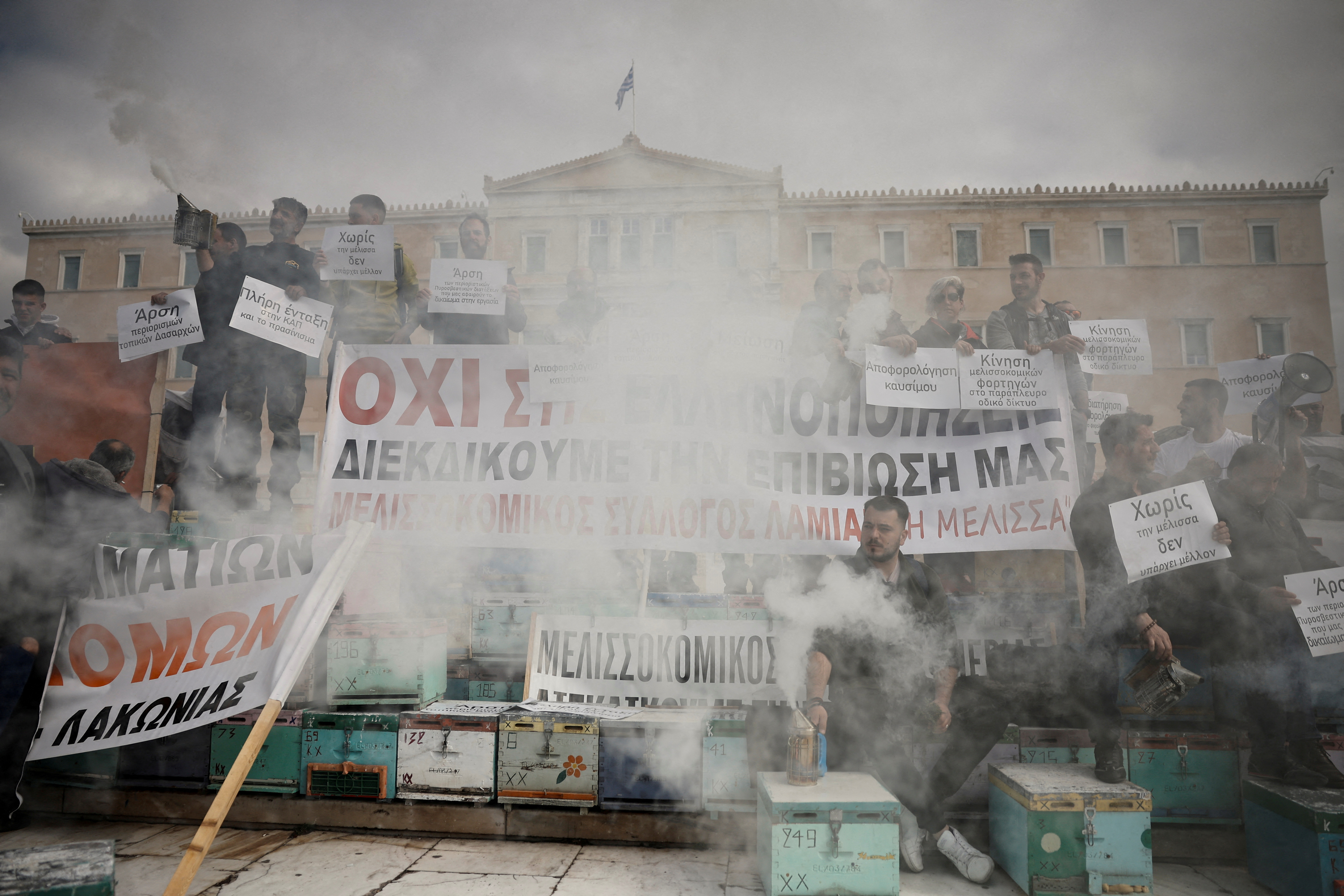 Greek beekeepers use smokers, among stacked hives in front of the country's parliament, to protest over issues affecting their trade, one day after thousands of farmers with their tractors descended on the capital, in Athens, Greece, February 22