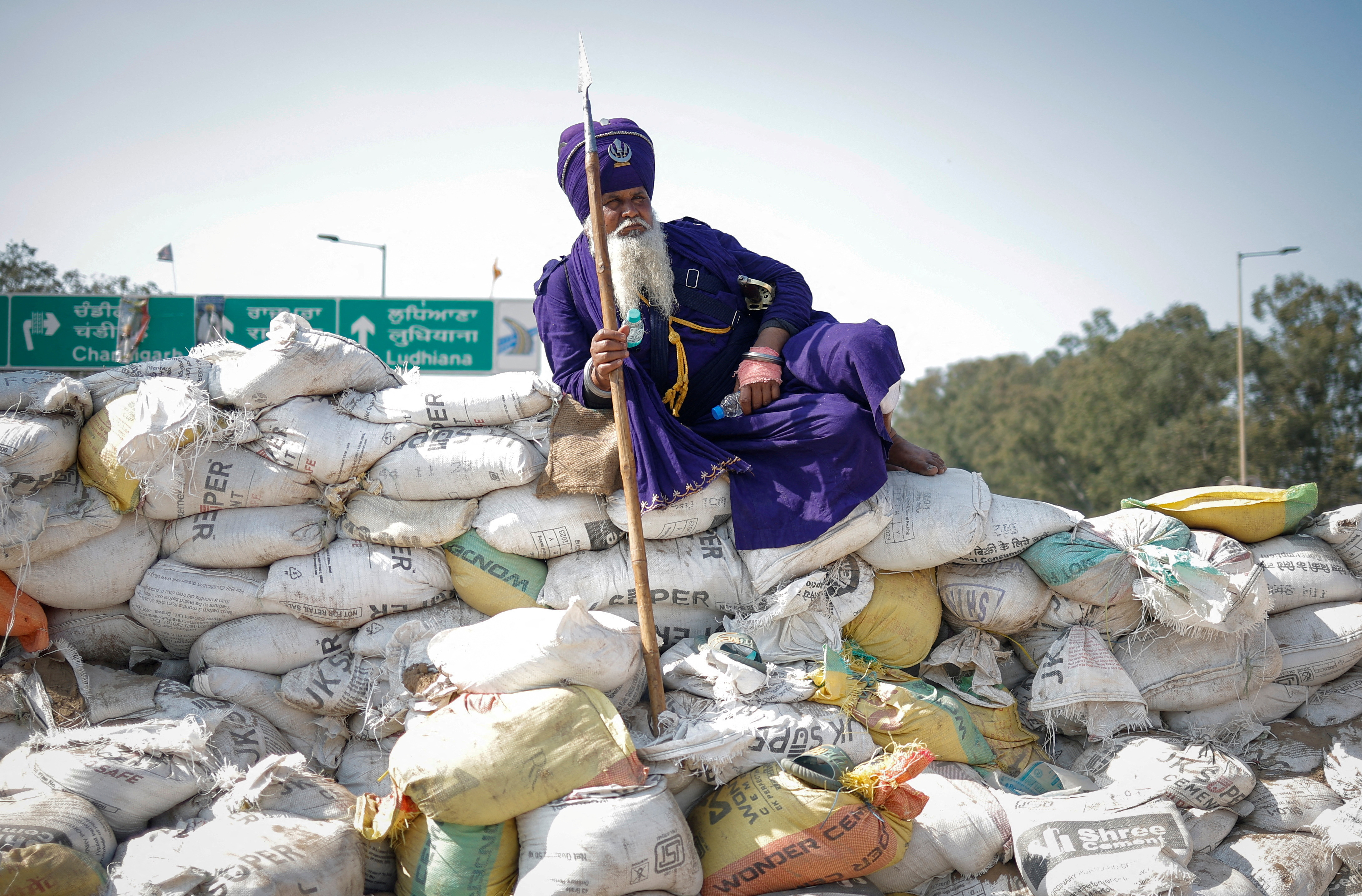 A Nihang or a Sikh warrior rests on a makeshift barricade of sand bags, at a protest site during the march towards New Delhi to push for better crop prices promised to them in 2021, at Shambhu Barrier, the border between Punjab and Haryana states, India February 23