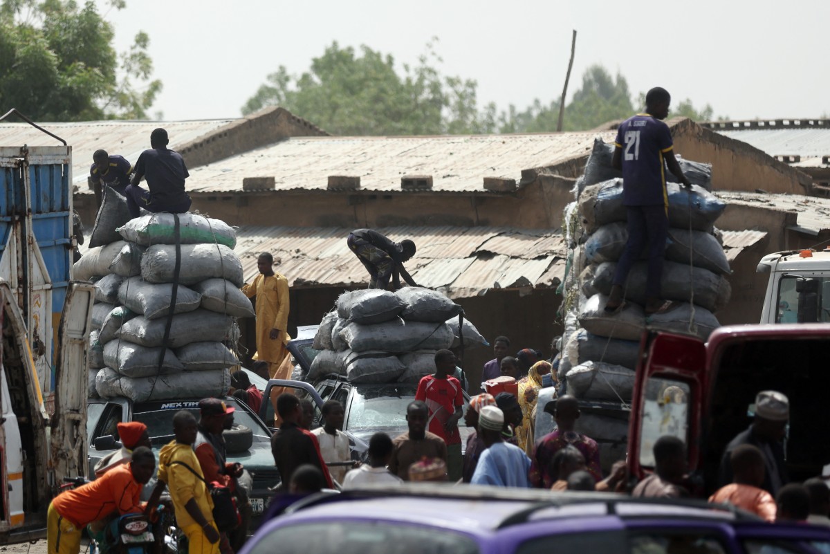 Bags of charcoal are offloaded at the market in Jibia