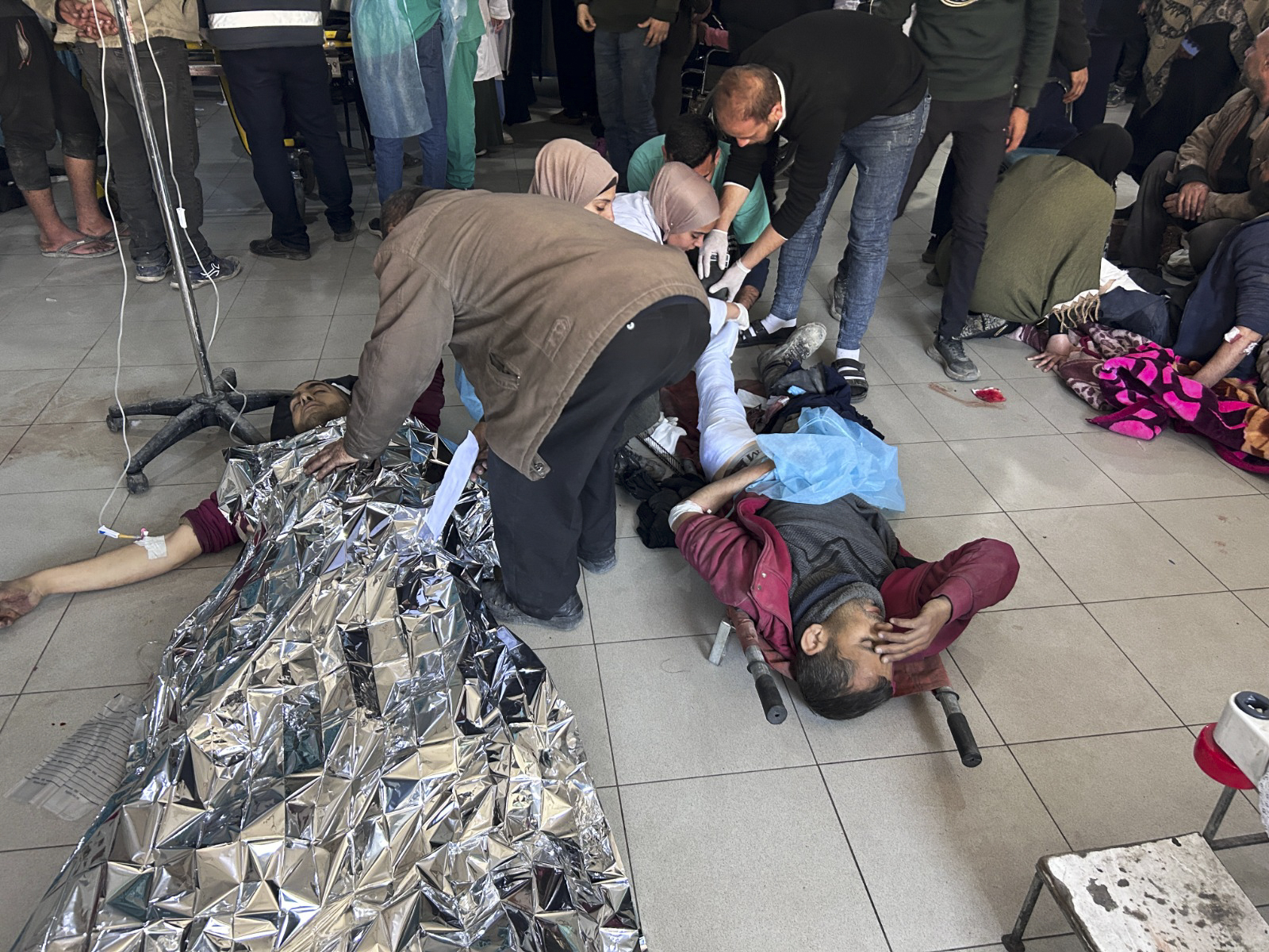 Palestinians wounded in an Israeli strike while waiting for humanitarian aid on the beach in Gaza City are treated in Shifa Hospital