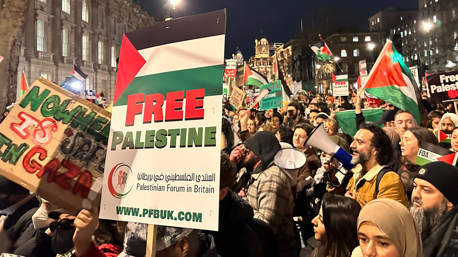 Protesters holding signs in front of the UK PM Rishi Sunak's residence.