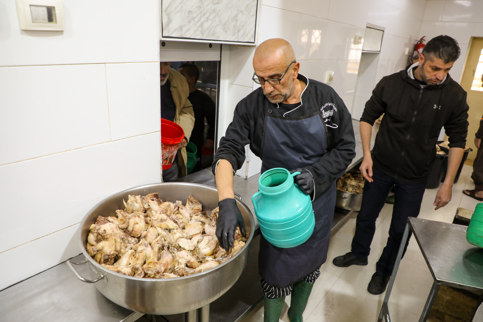 A chef adding water to a pot