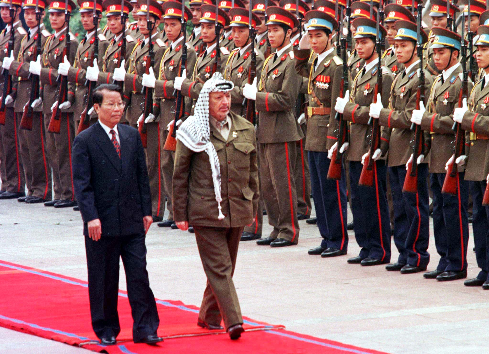 Palestinian President Yasser Arafat walks with Vietnamese President Tran Duc Luong as he inspects an honour guard at his formal welcoming ceremony in Hanoi April 9. Arafat has been on a whirlwind international tour aimed at gauging support for a unilateral Palestinian declaration of independence once an interim self-rule agreement with Israel expires in May. AJS/DL