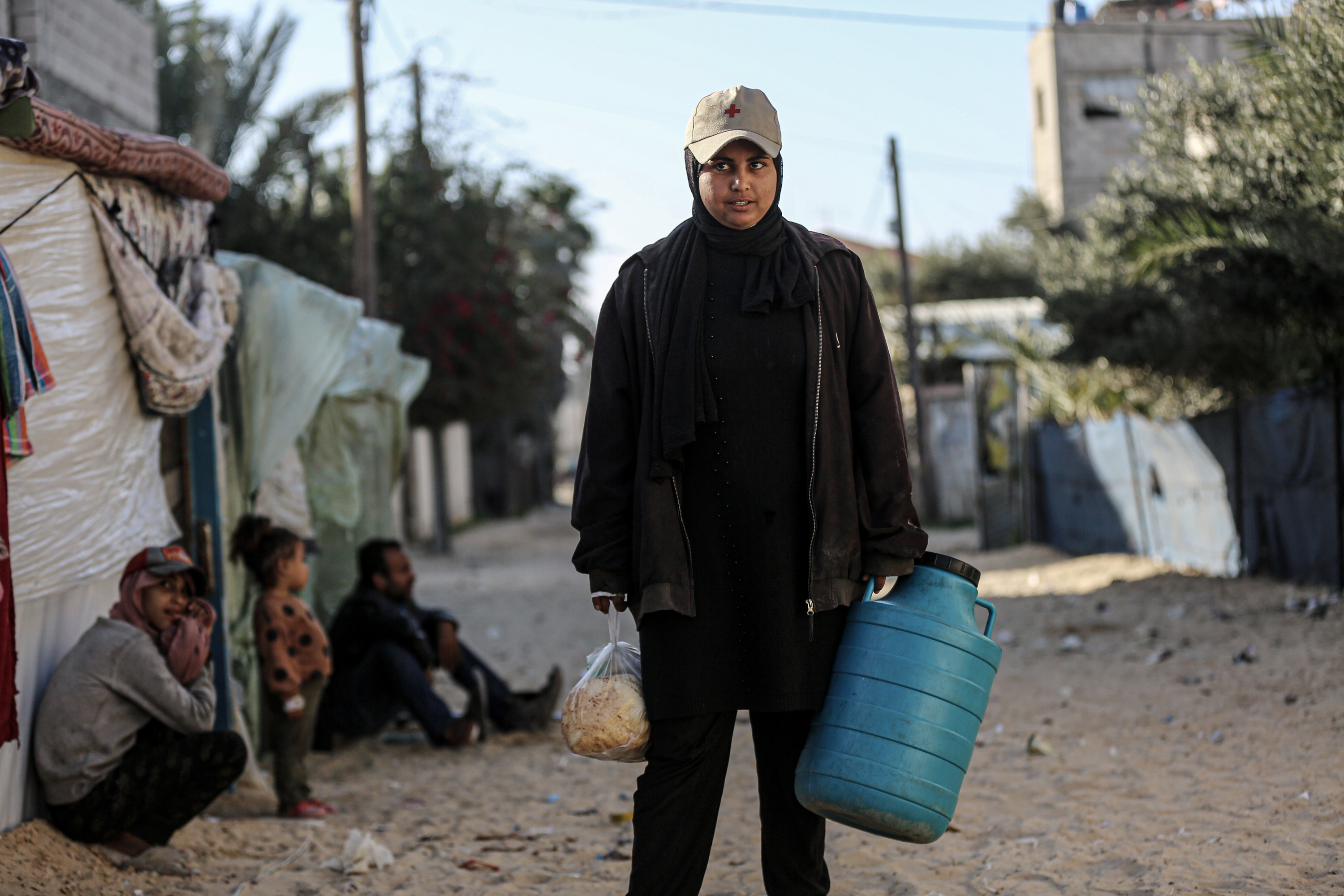 ‘I have completely forgotten that I am female,’ says Marah, 19, who fills a water container for her family of nine as one of her daily chores