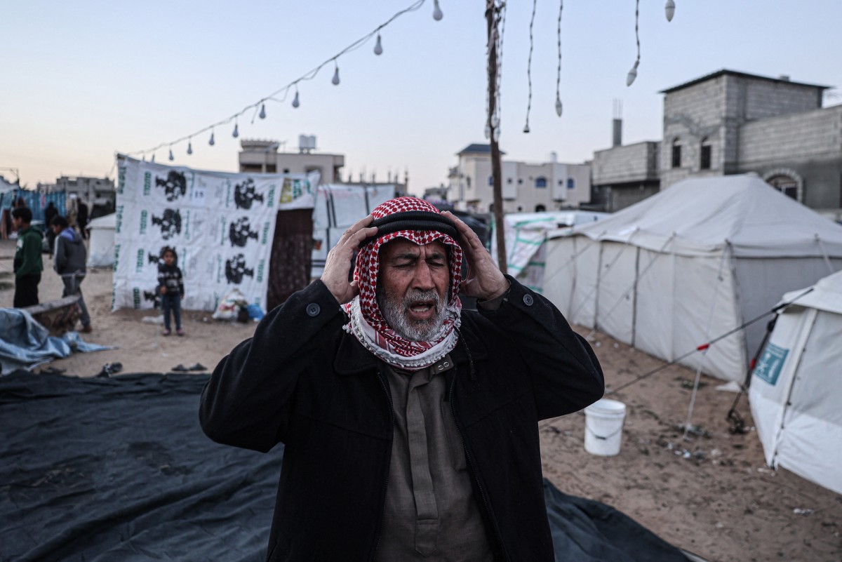 A displaced Palestinian man prays before breaking the fast