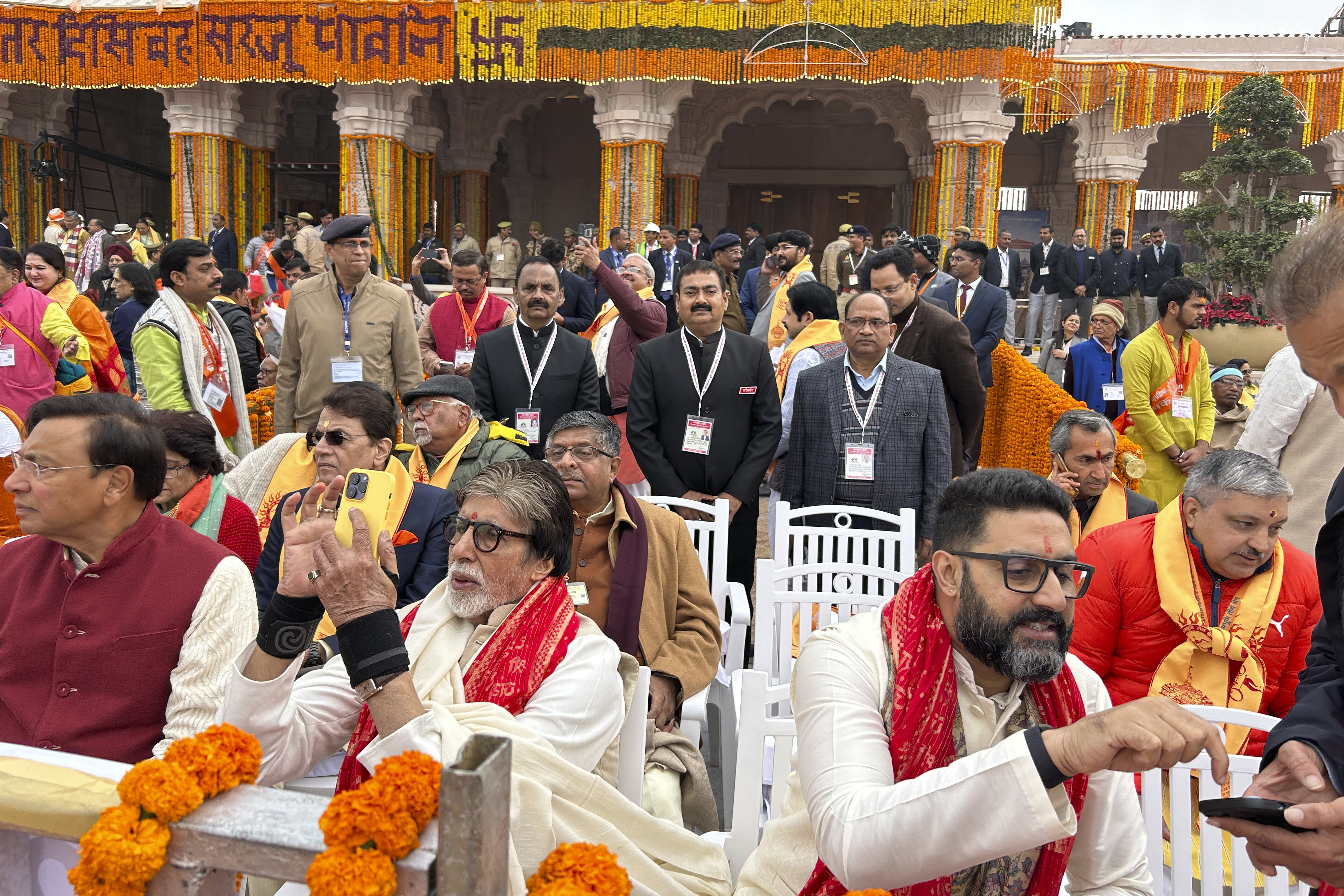 Bollywood actor Amitabh Bachchan, center left with his son Abisheik Bachchan, center right along with other chief guests sit awaiting the opening of a temple dedicated to Hindu deity Lord Ram, in Ayodhya, India, Monday, Jan.22, 2024. Indian Prime Minister Narendra Modi is set to open a controversial Hindu temple built on the ruins of an ancient mosque in the holy city of Ayodhya in a grand event that is expected to galvanize Hindu voters months before a general election. (AP Photo/Rajesh Kumar Singh)