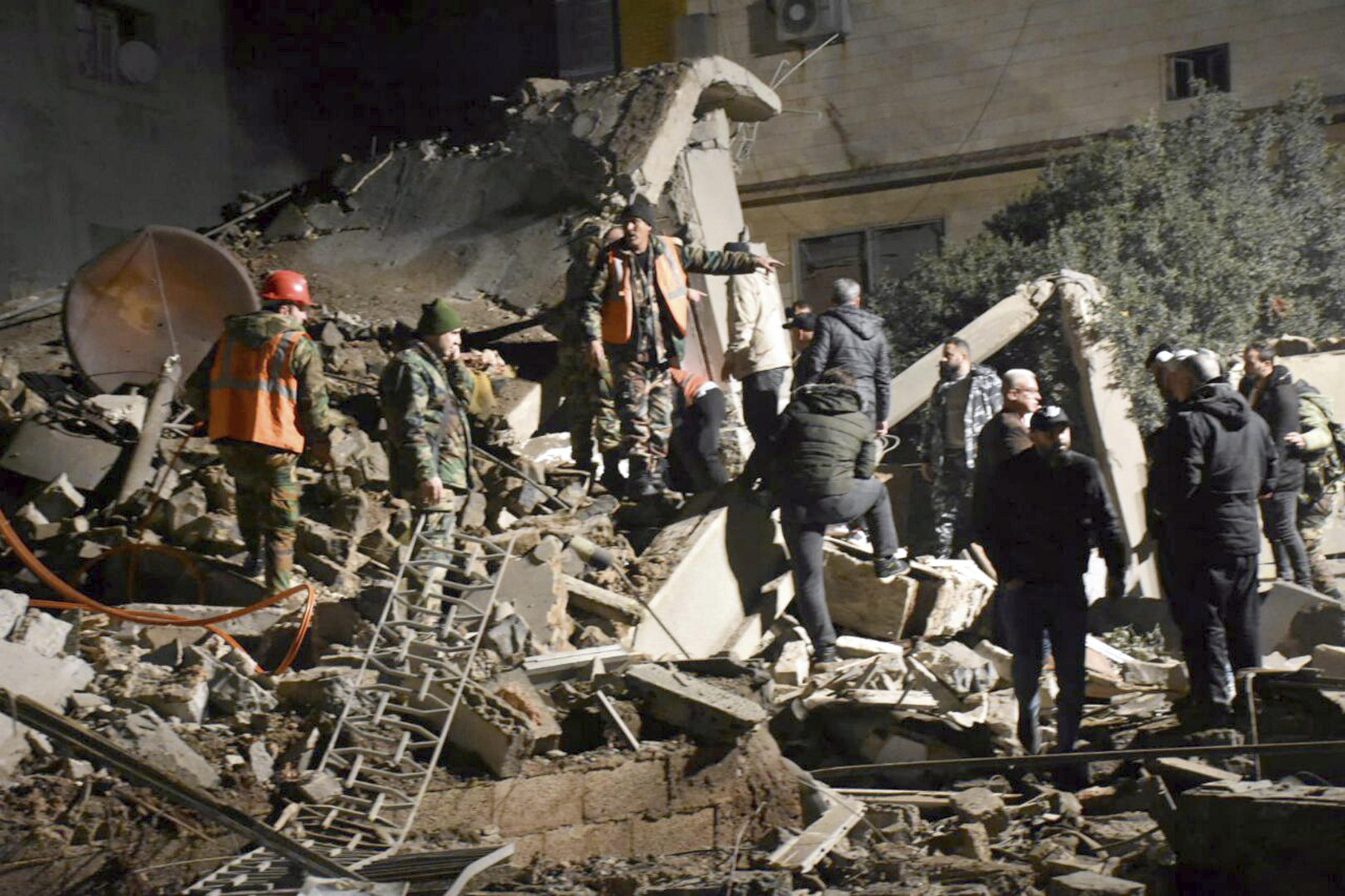People gather to rescue others after Israeli airstrikes in Homs