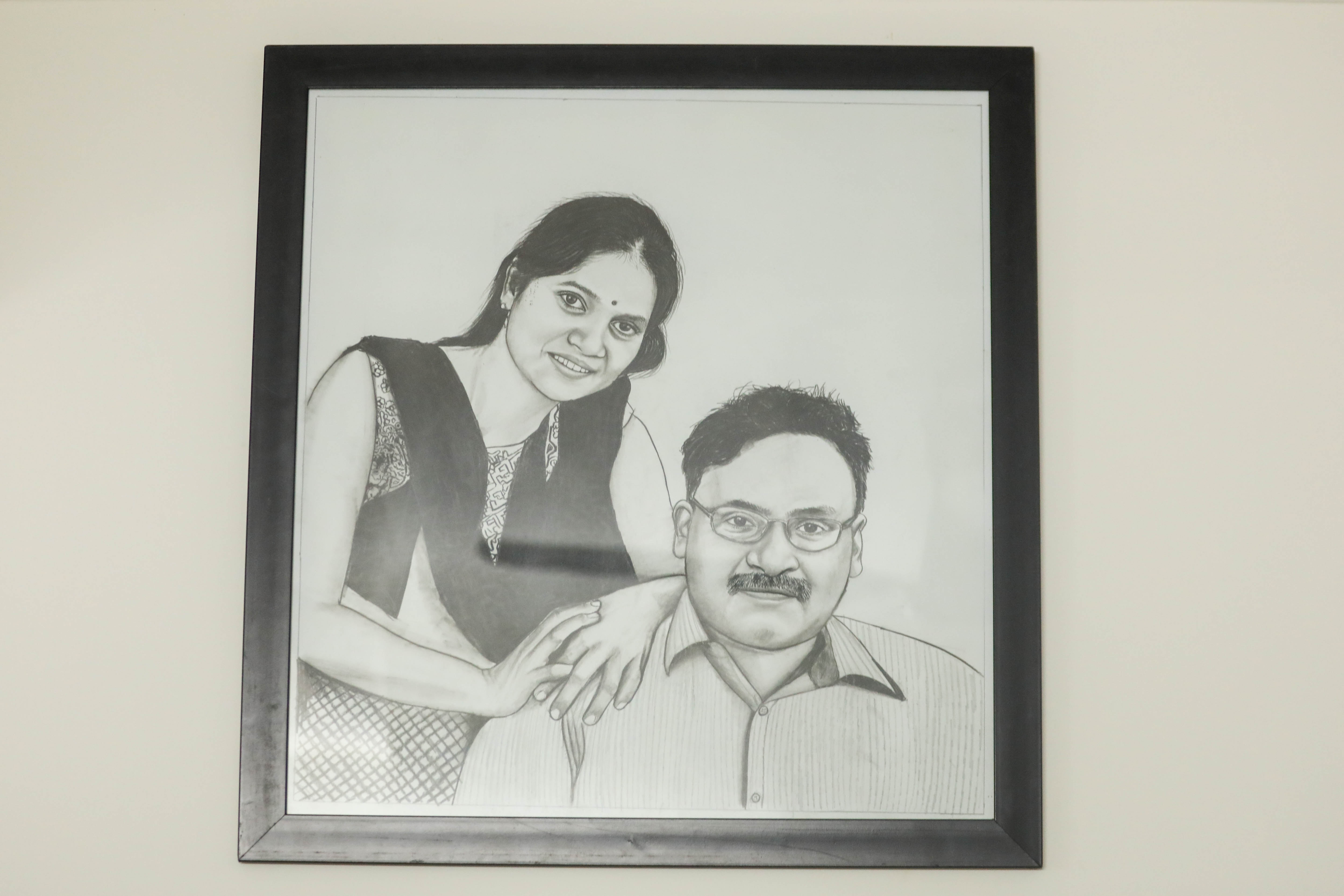 A sketch of GN Saibaba and his wife Vasantha Kumari hanging at their rented home in New Delhi [Md Meharban/Al Jazeera]