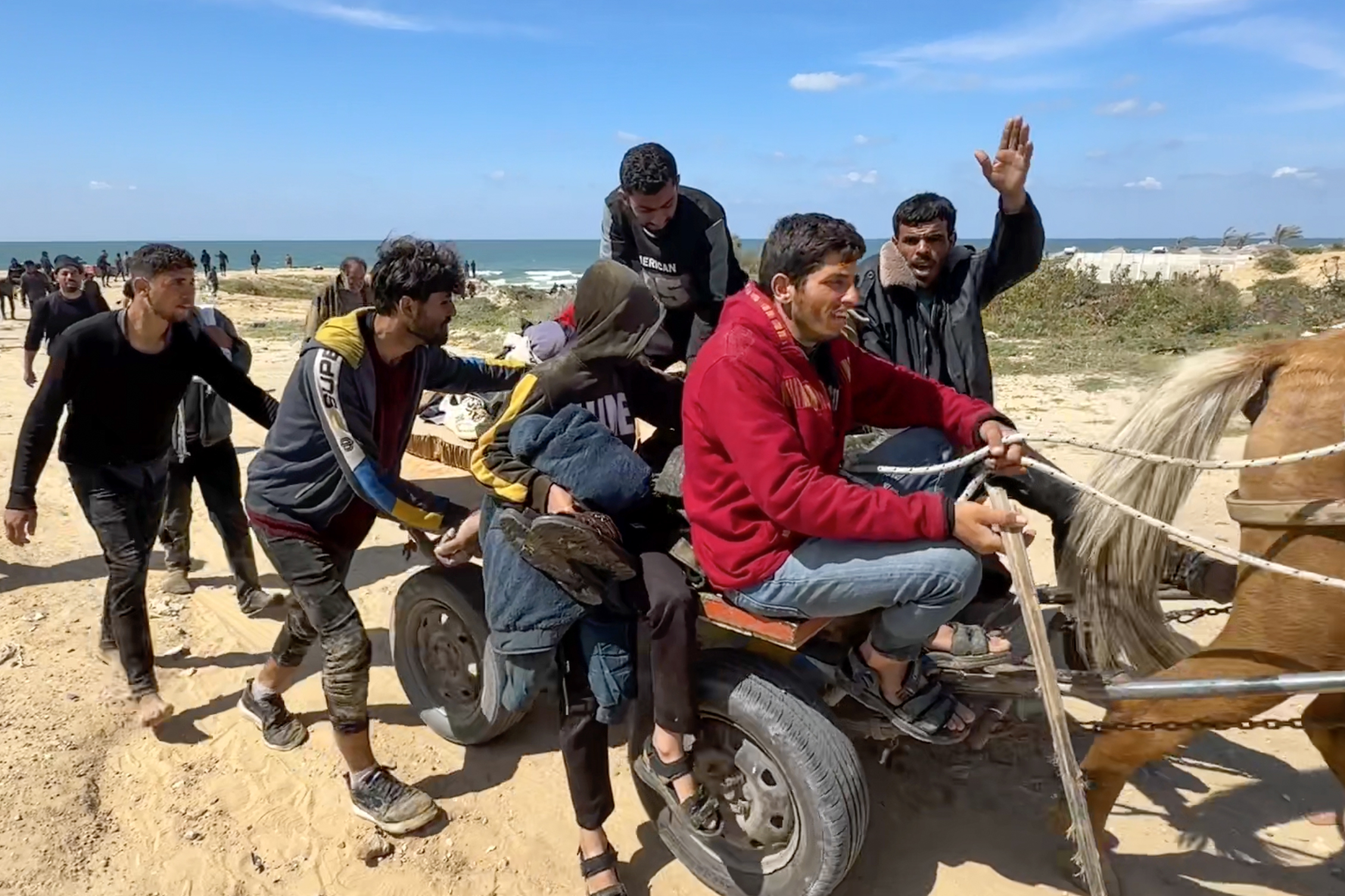 horse and cart carrying people on beach