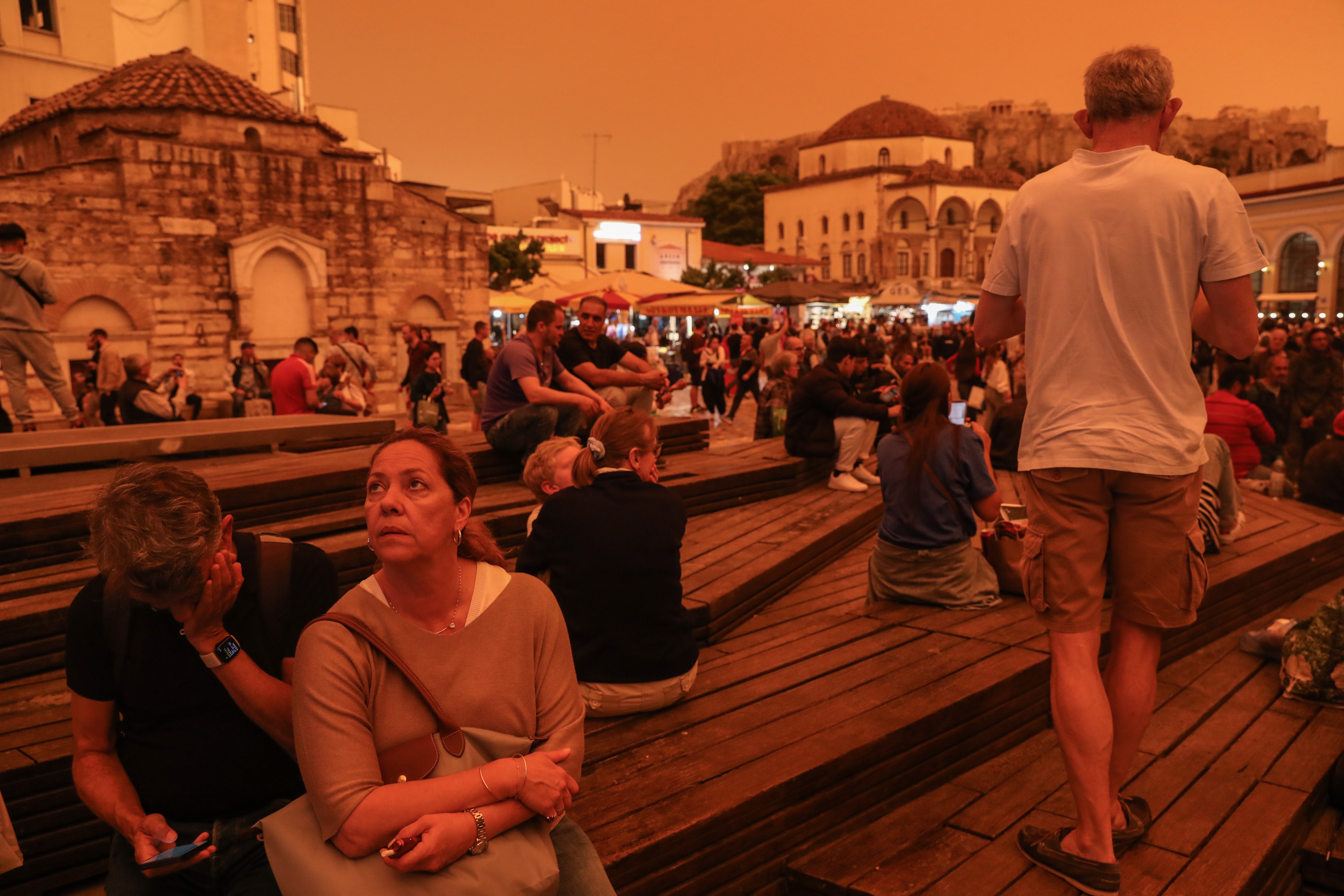 People stroll while African dust covers the sky of Athen