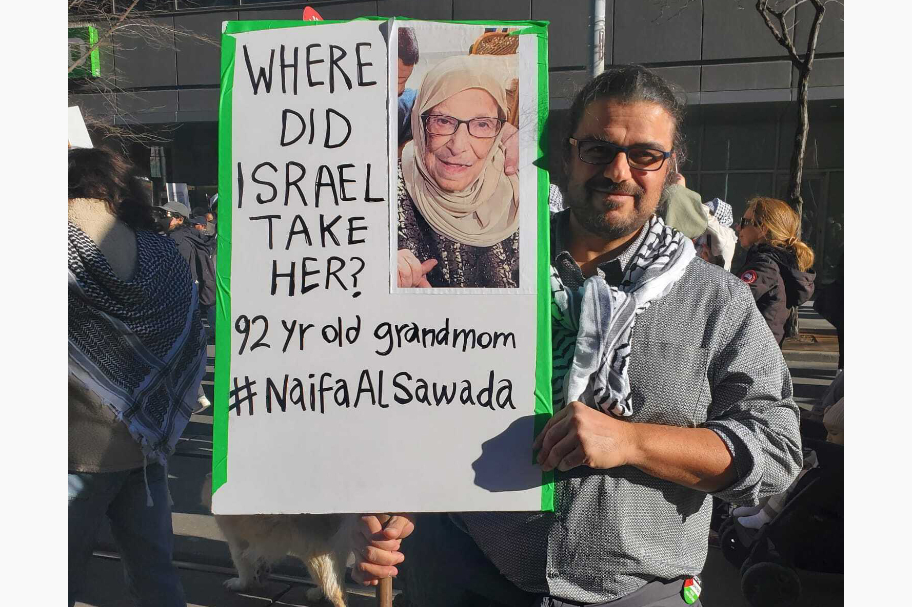 Ayman Ayyad with a sign demanding answers after the disappearance of his grandmother