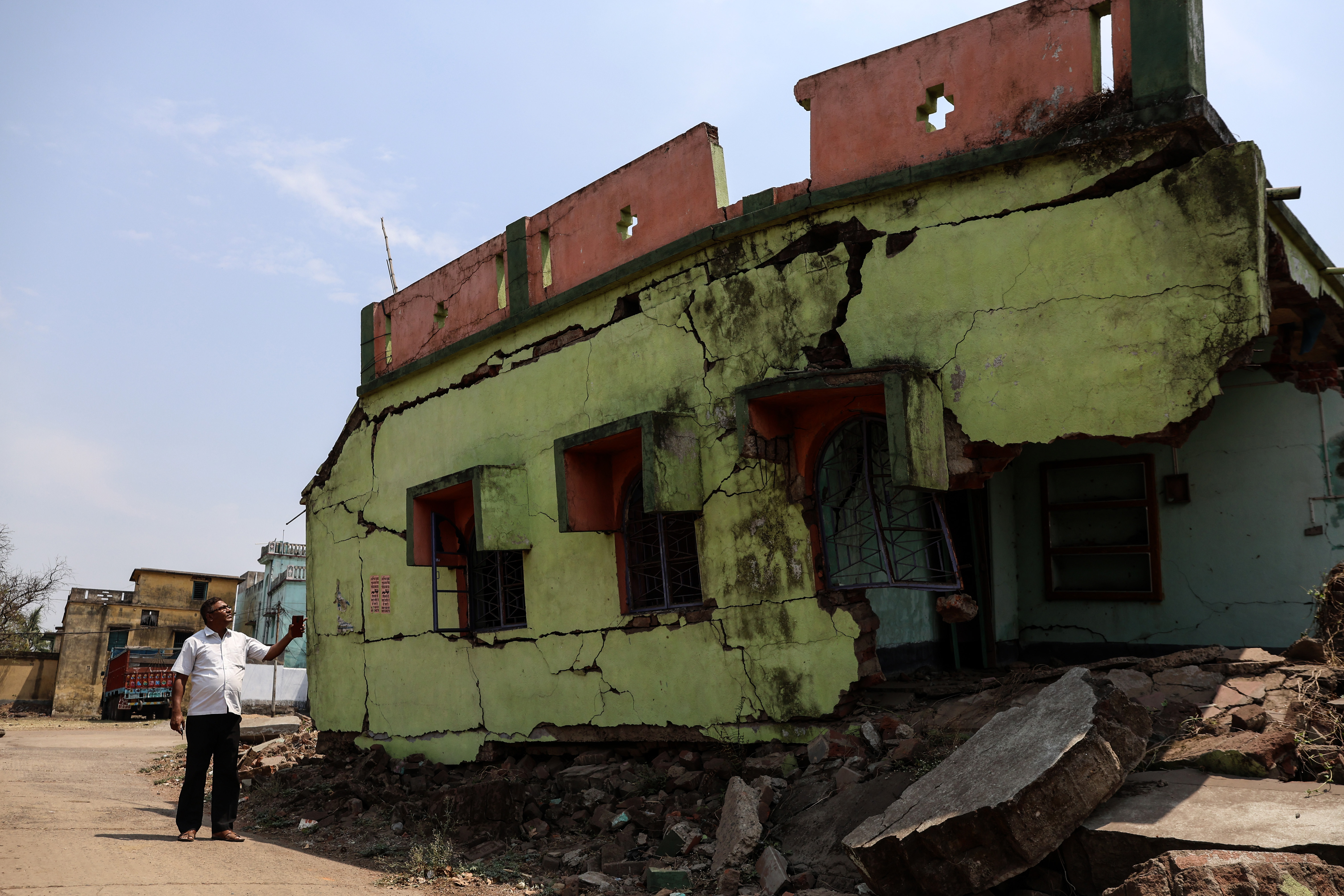 Swaraj Das, an activist from the Project Affected People’s Association (PAPA), looks at a house affected by a landslide in Harishpur, West Bengal