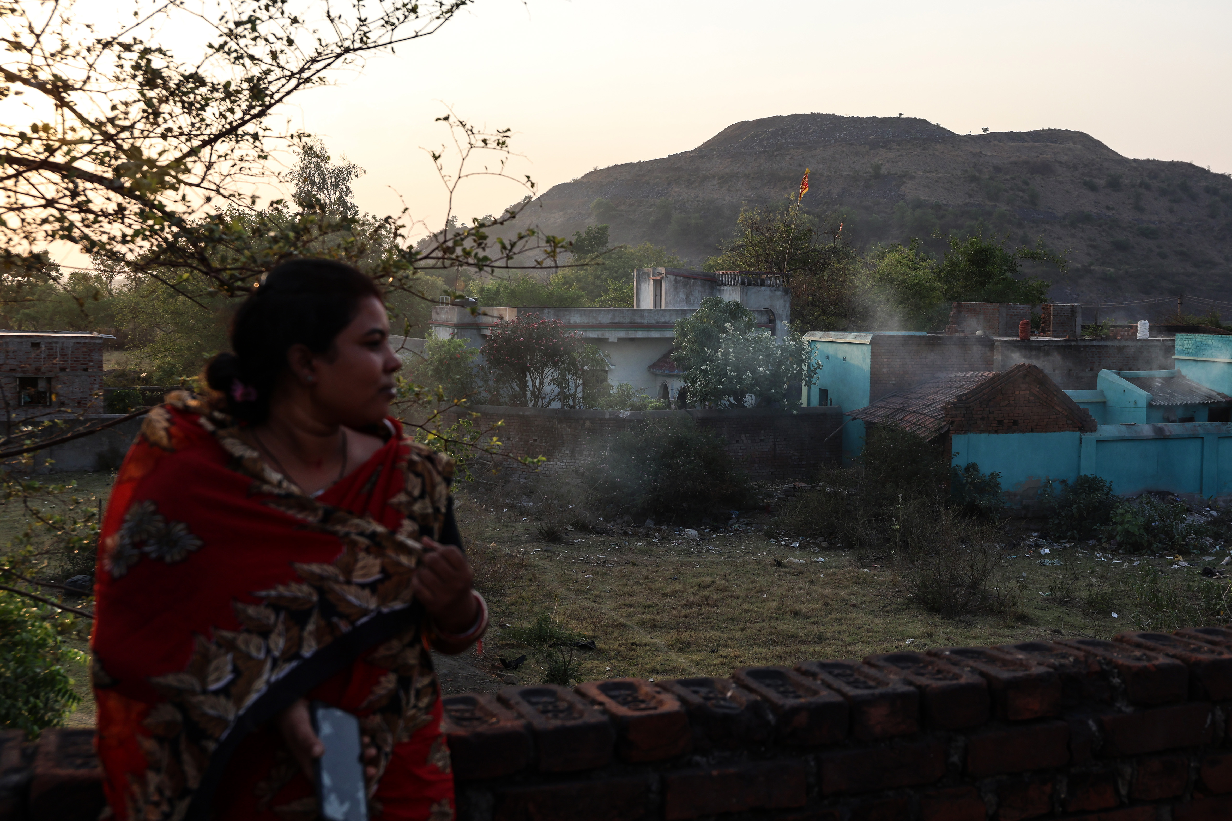 Asha Bauri, 30, stands on the terrace of her house near a coal mine operated by Integrated Coal Mining Limited in Rakhakura, West Bengal, India