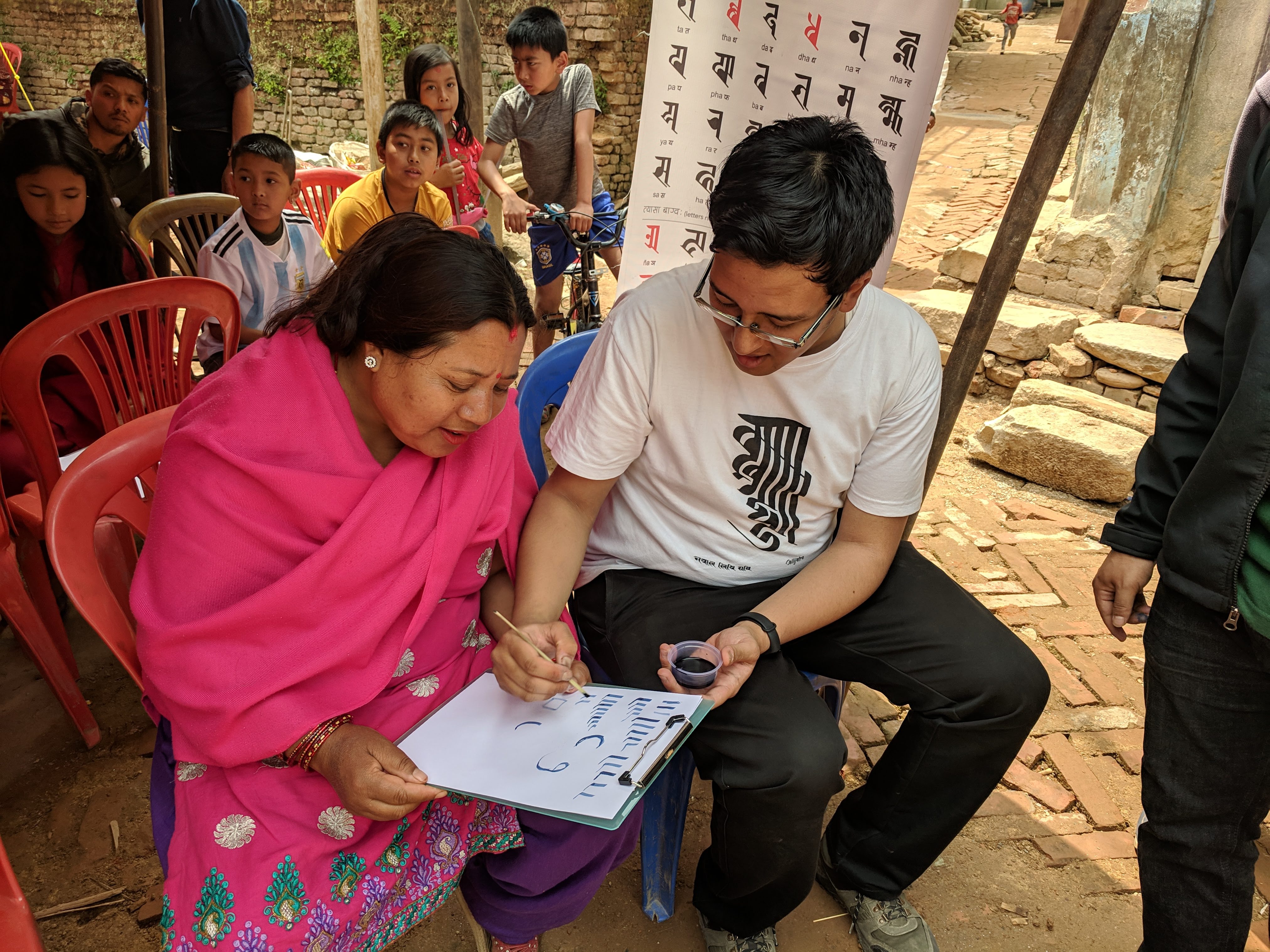 Suyogya Ratna Tamrakar, an original member of Callijatra, assists new students in Ranjana Lipi. Tamrakar also designed the ‘Nepal Lipi-Ranjana Lipi’ IOS app [Courtesy of Callijatra]