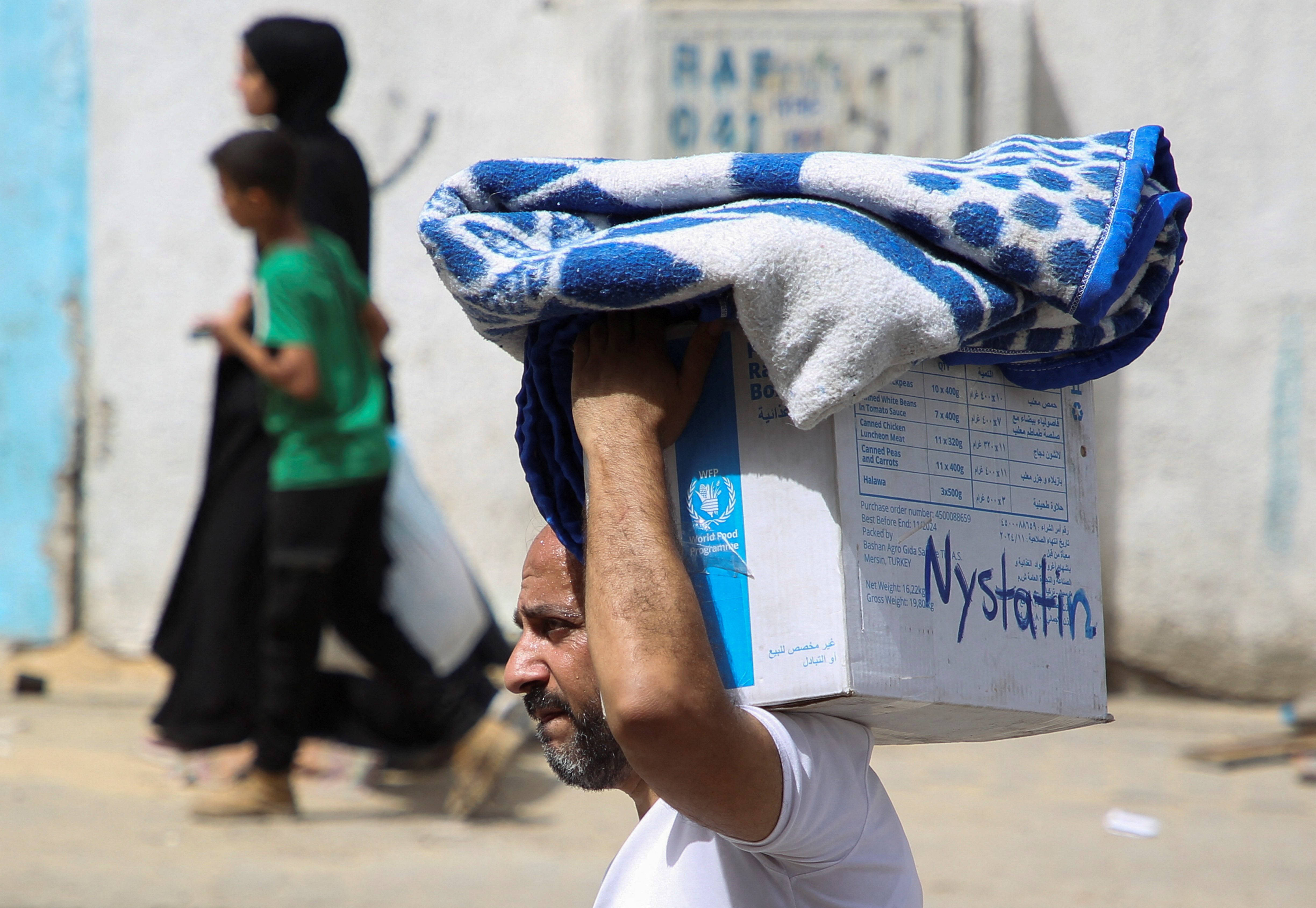 A man carries belongings, as Palestinians prepare to evacuate, after Israeli forces launched a ground and air operation in the eastern part of Rafah