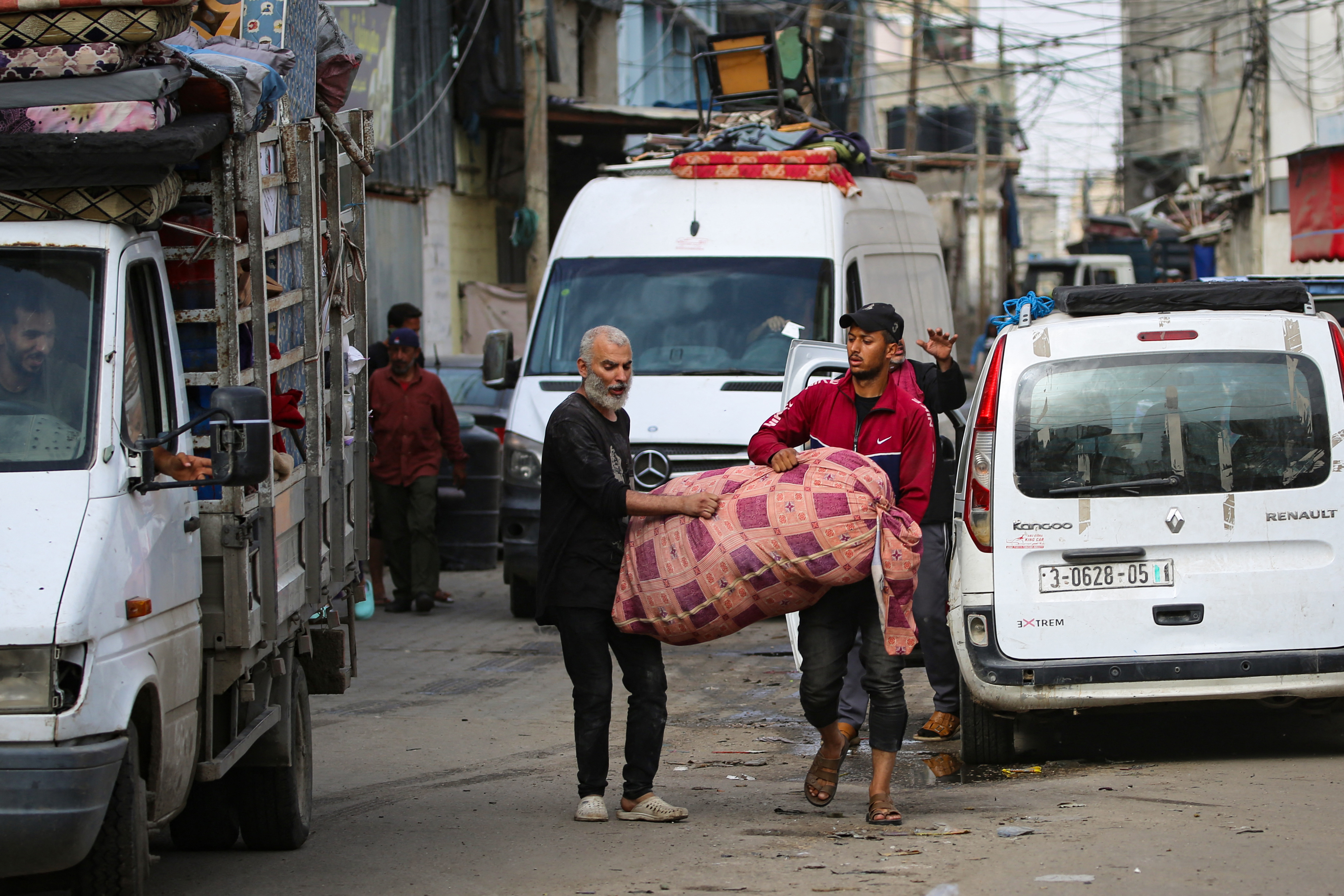 Palestinians carry their belongings as they flee Rafah in the southern Gaza Strip to a safer location on May 11, 2023