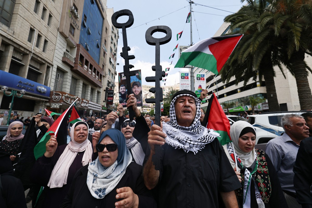 Palestinian protesters hold symbolic keys during a rally in the northern West Bank city of Nablus