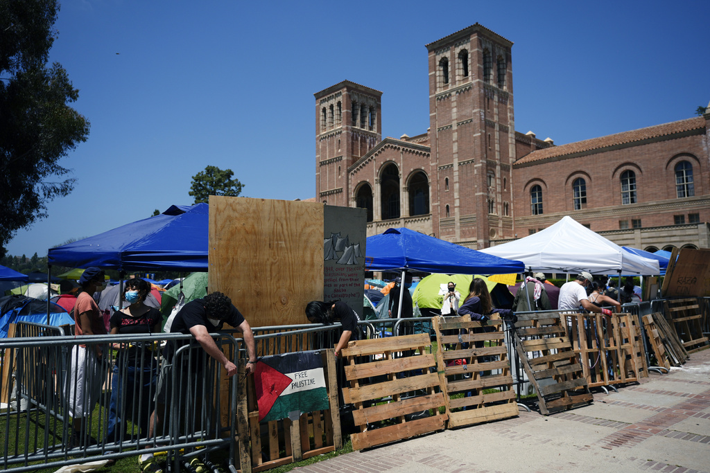 Pro-Palestine demonstrators restore a protective barricade at UCLA
