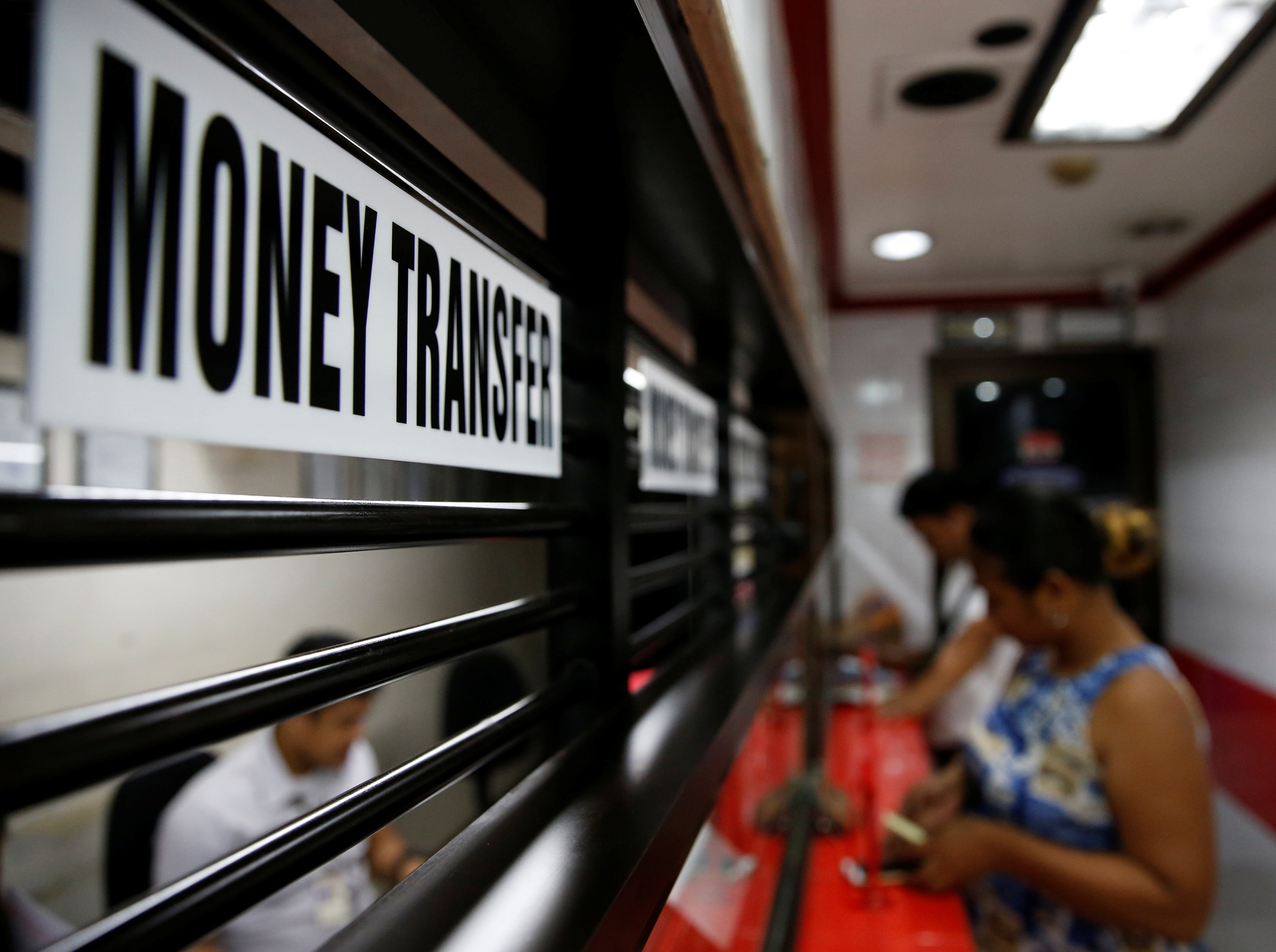 Customers receive money from families working abroad at a money remittance centre in Makati City, Metro Manila, Philippines