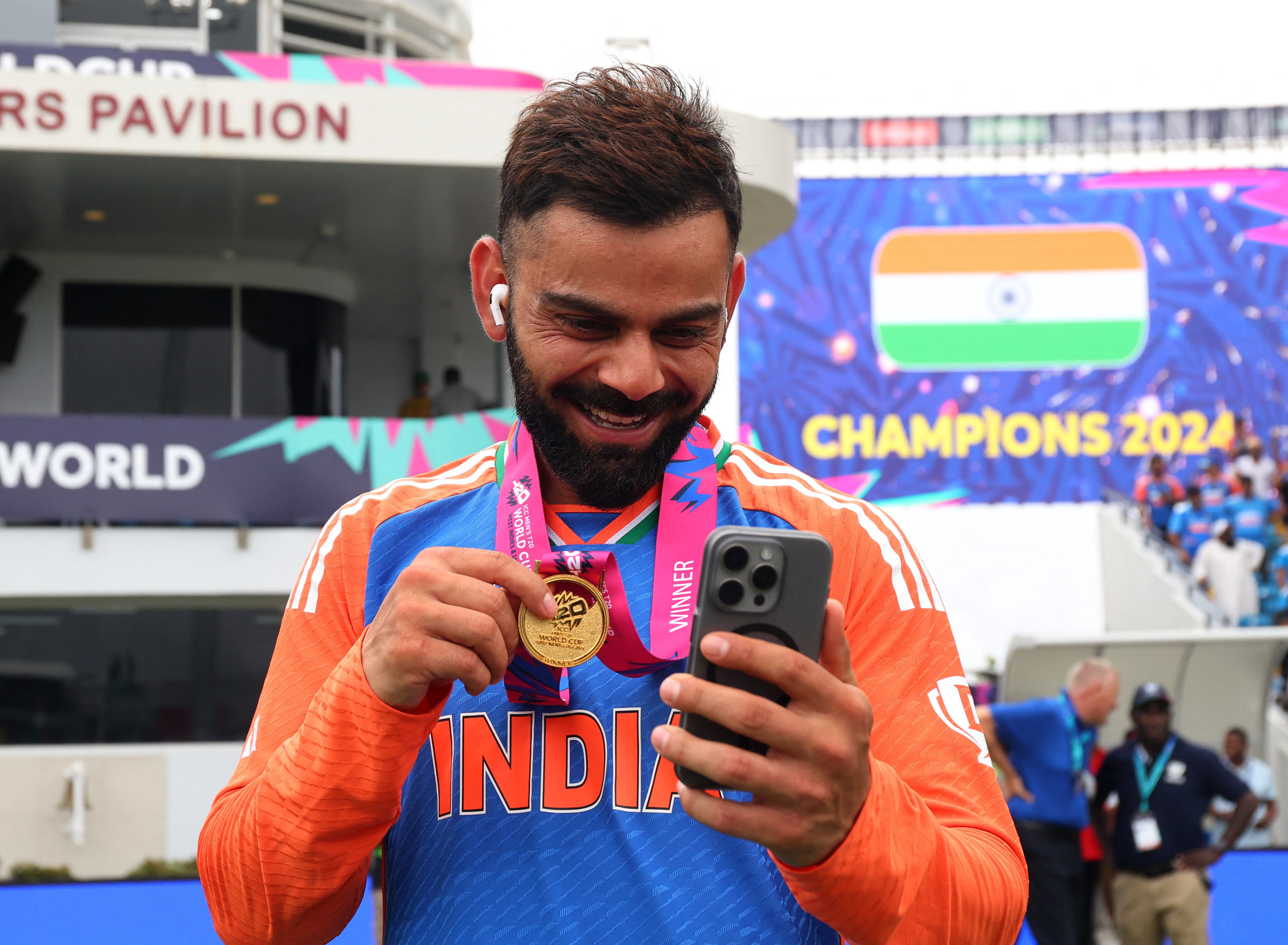 India's Virat Kohli talks to his family on his mobile phone as he celebrates after winning the T20 World Cup