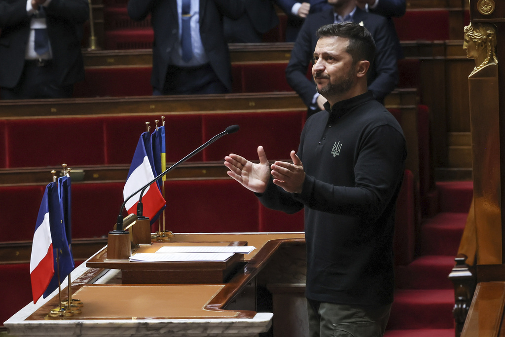 Ukrainian President Volodymyr Zelenskyy applauds after delivering a speech at France's National Assembly